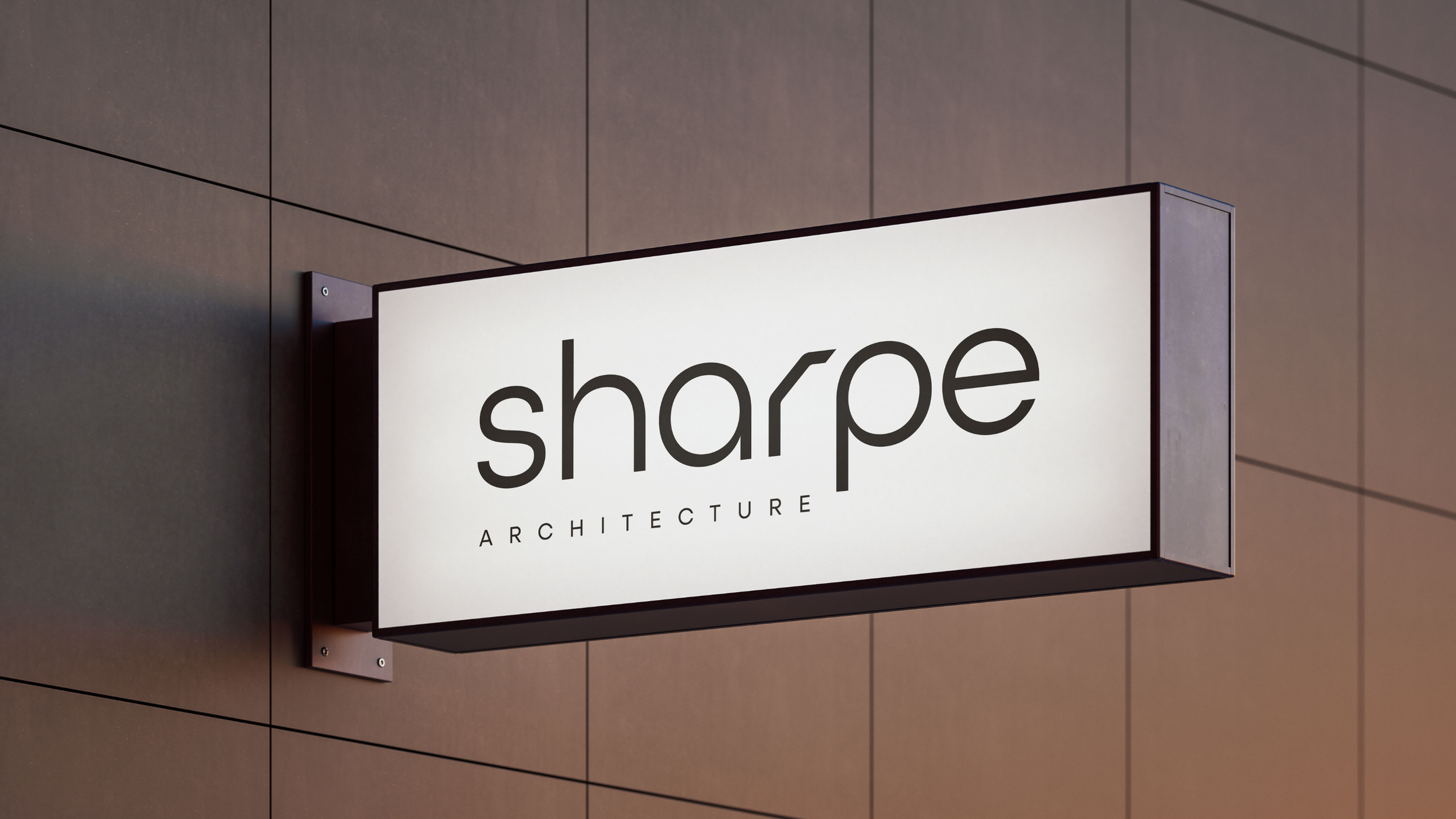 Backlit sign with the words 'sharpe ARCHITECTURE' mounted on a wall.