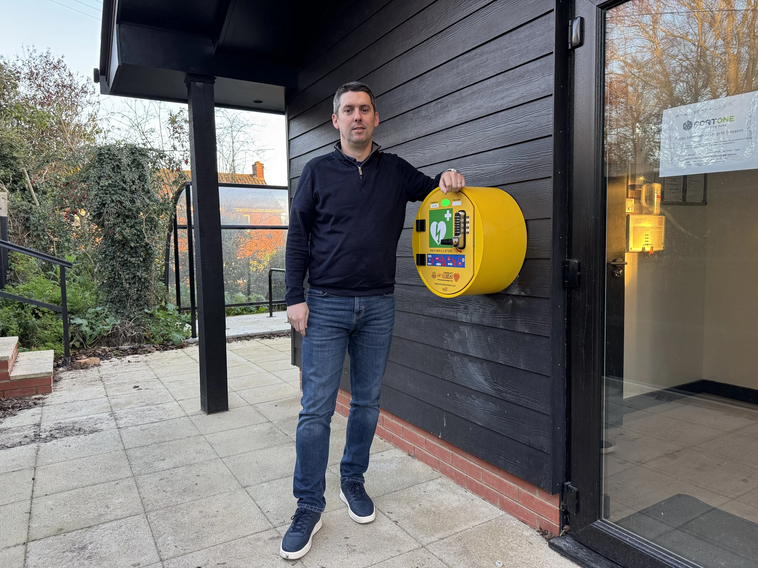 chris standing next to a defibrillator