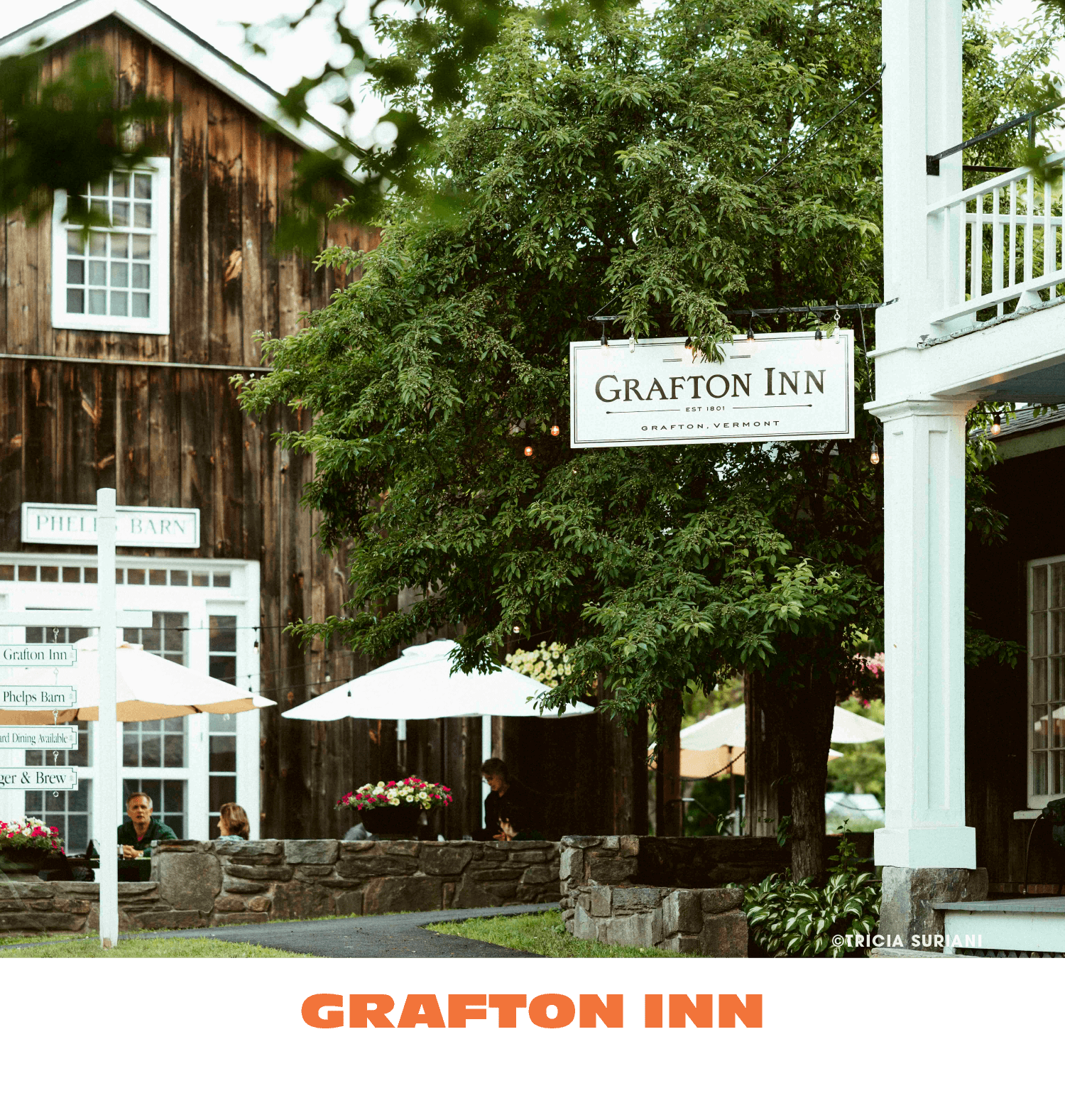Exterior view of Grafton Inn in Vermont with outdoor seating, umbrellas, and greenery.