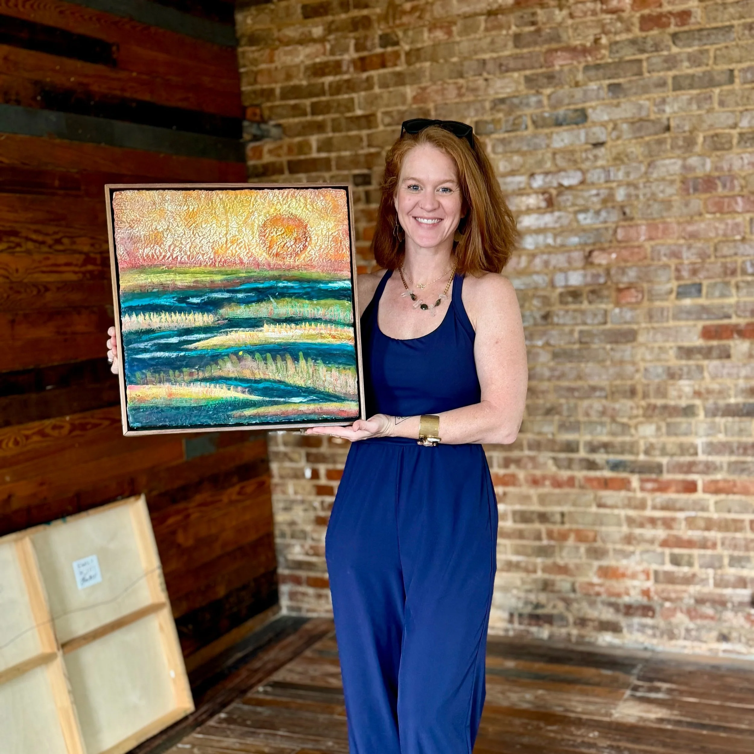 mily Scott holding an original encaustic painting in Beaufort SC
