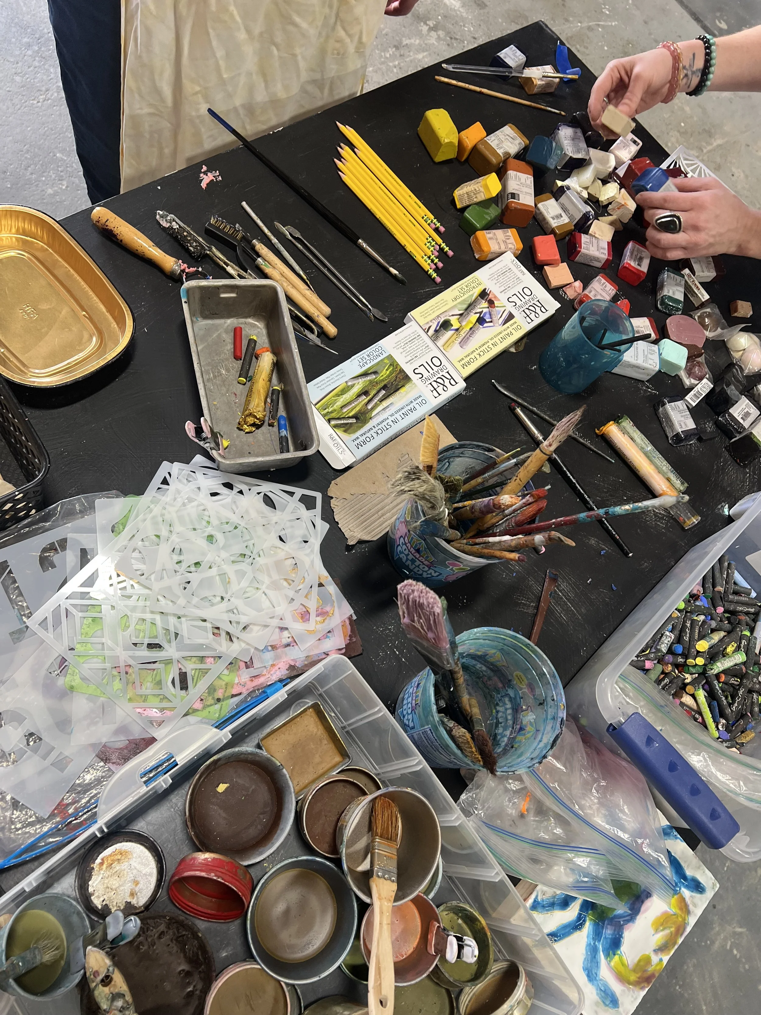 Participants exploring encaustic painting techniques with beeswax and brushes during an introductory workshop with Emily Scott