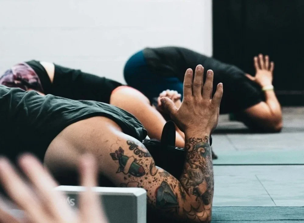 people in yoga hall meditating childs pose