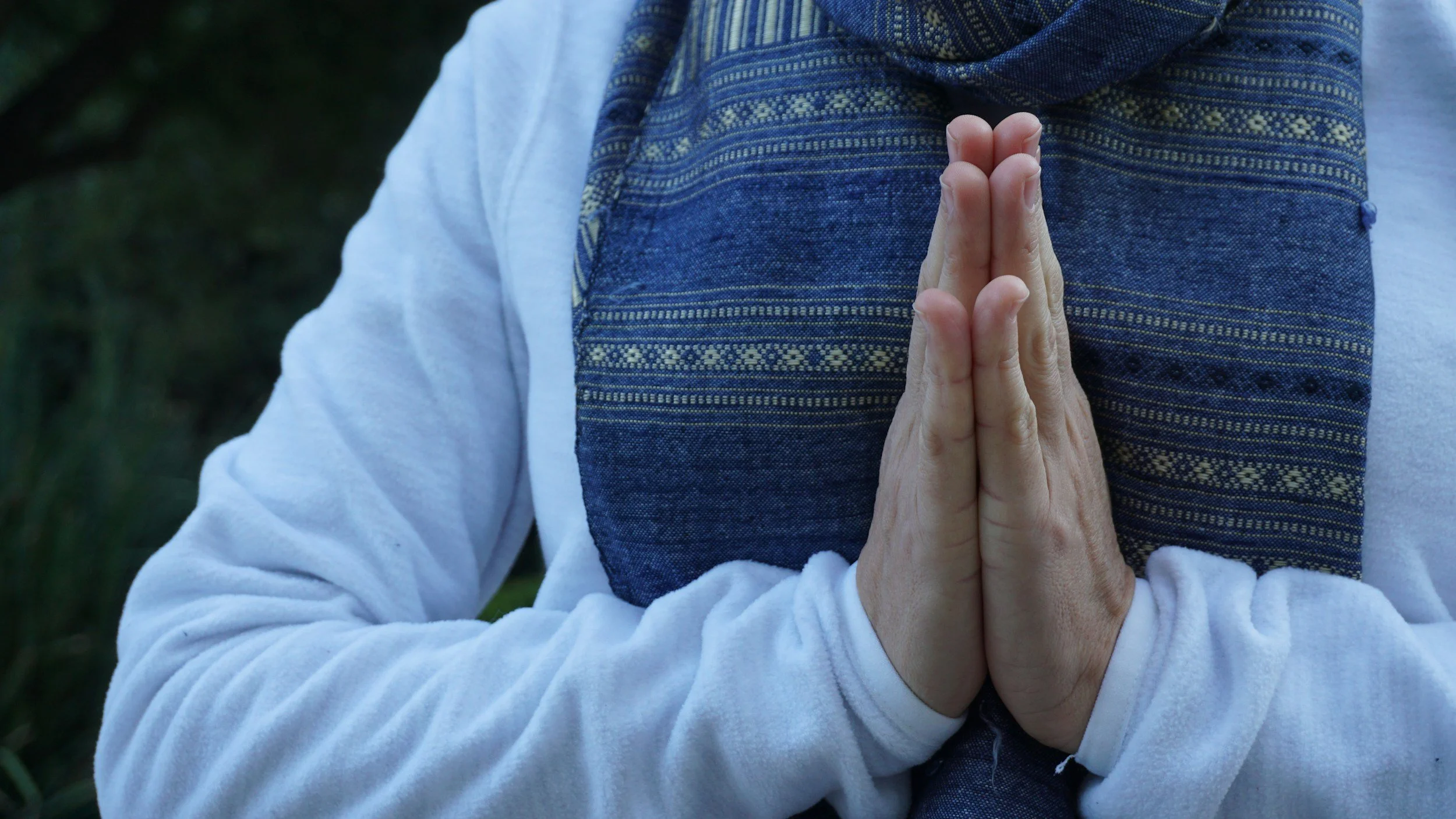 brown skinned person with hands in prayer pose