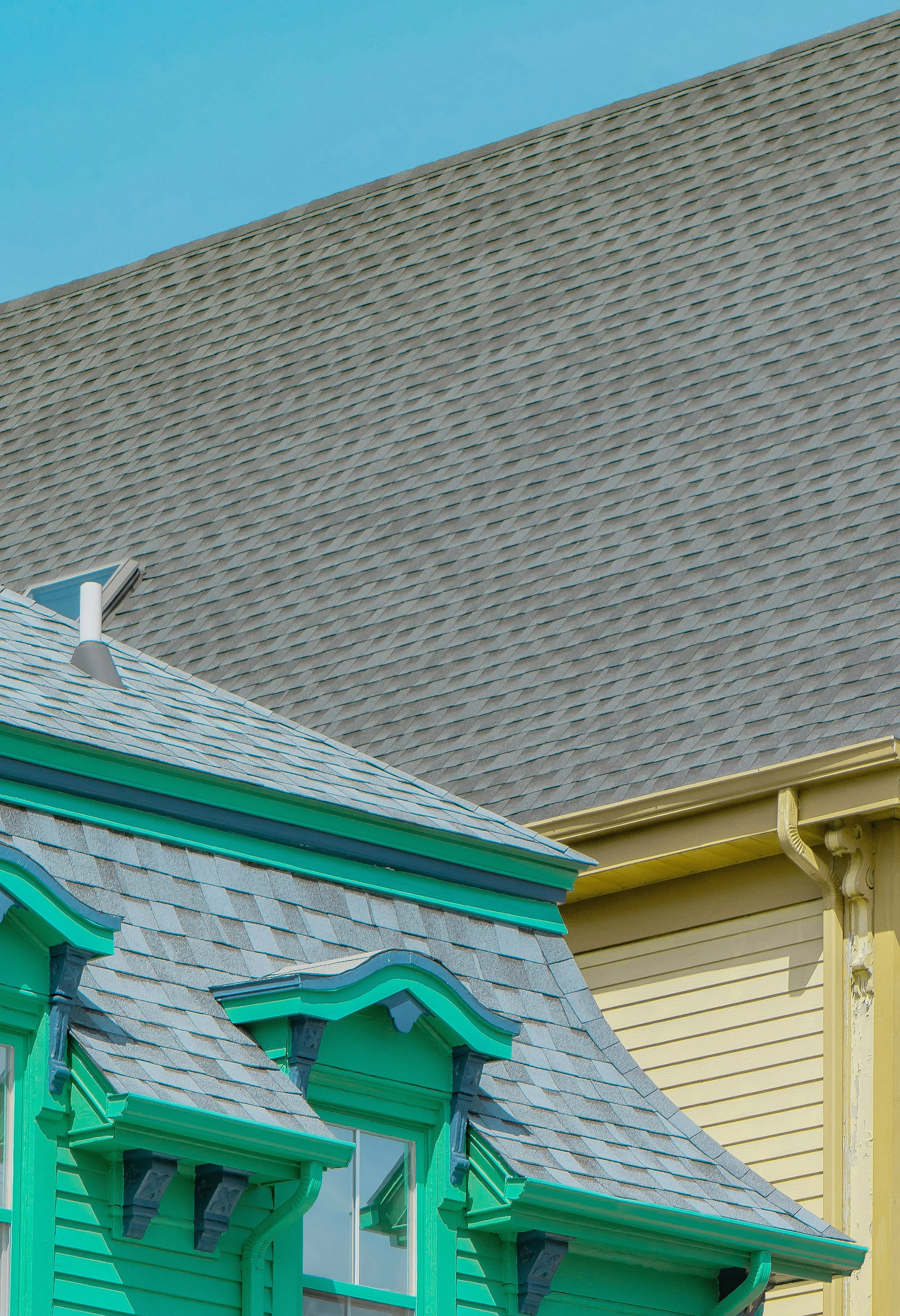 Shingled roofs on yellow and green houses
