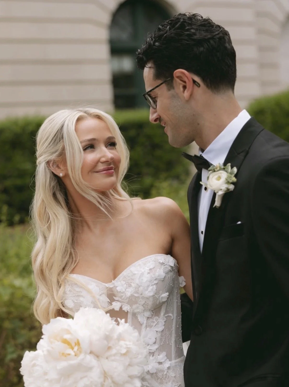 A bride and groom looking at each other during their wedding outside.