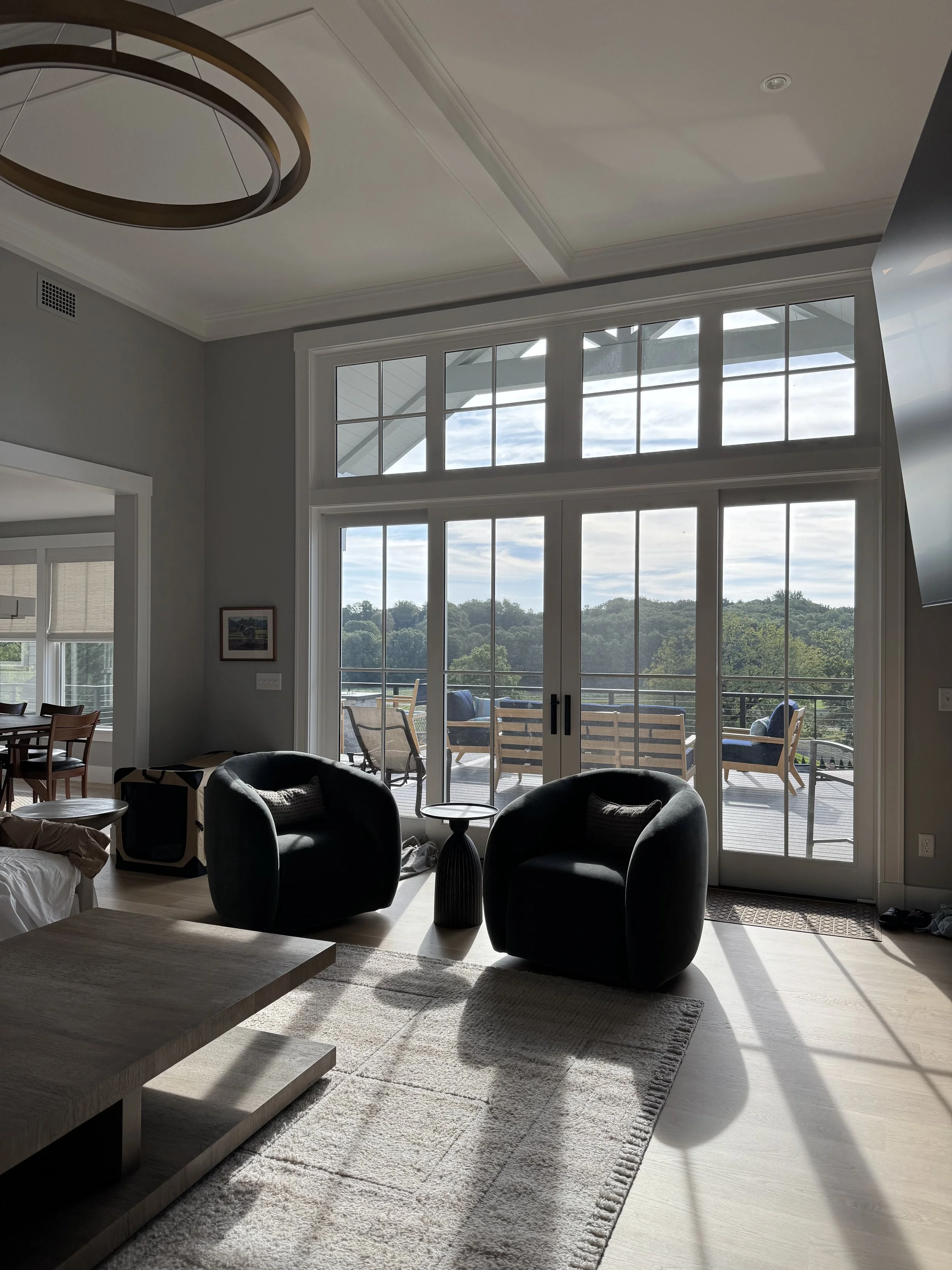 Modern living room with large glass doors and windows tinted for UV fading protection, reducing glare and protecting furniture from sun damage while maintaining natural light.