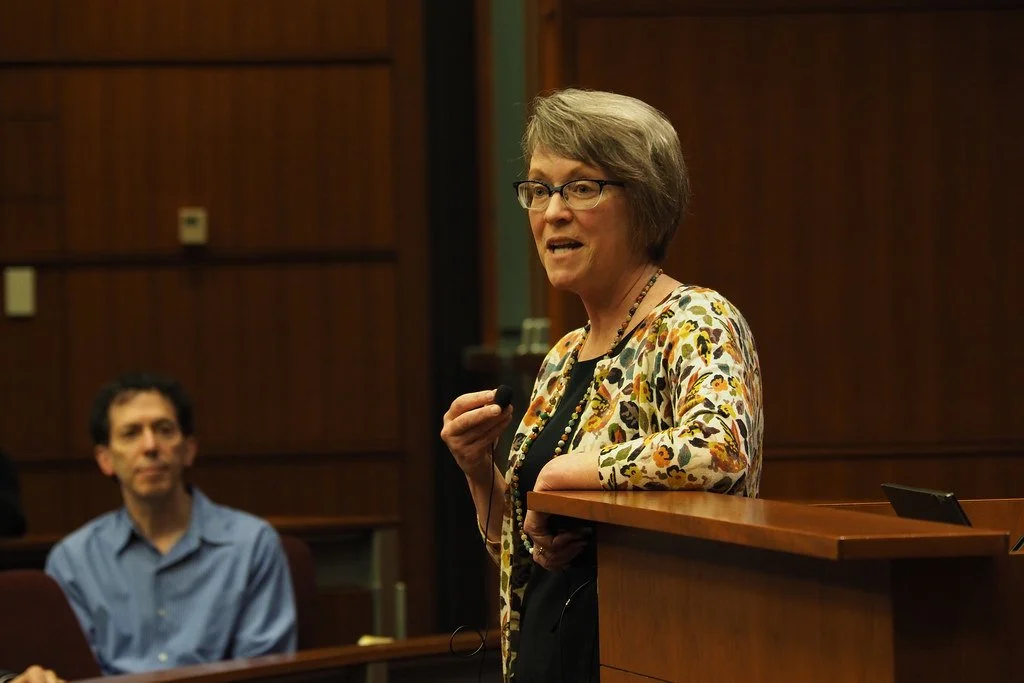 A person stands next to a podium during grand rounds