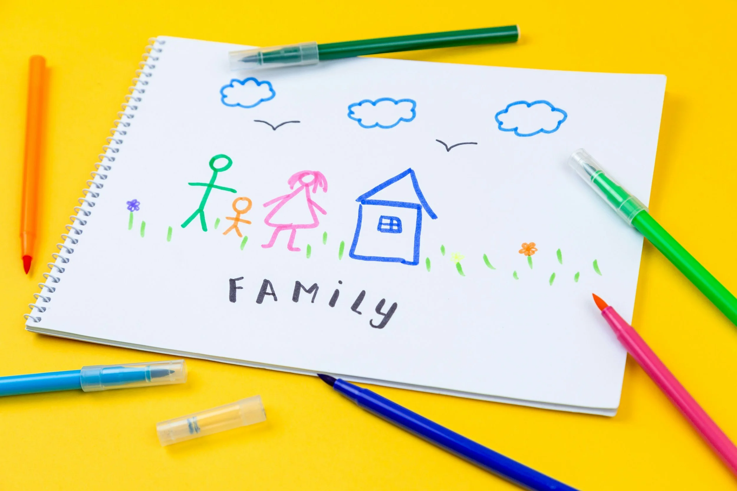 colorful drawing with markers on white paper with family and house