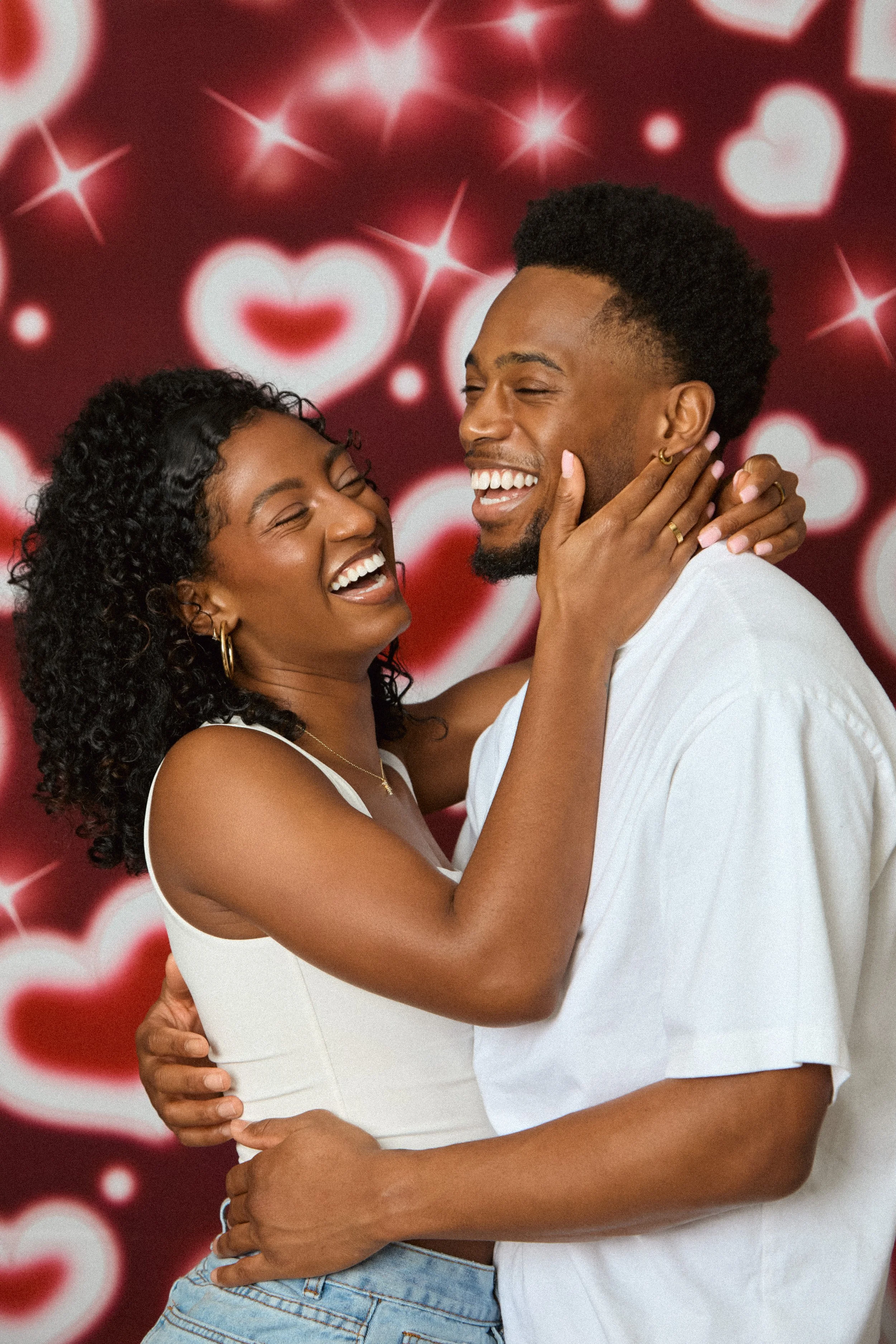 A happy couple joyfully embraces each other with a background of heart shapes and stars, celebrating love.