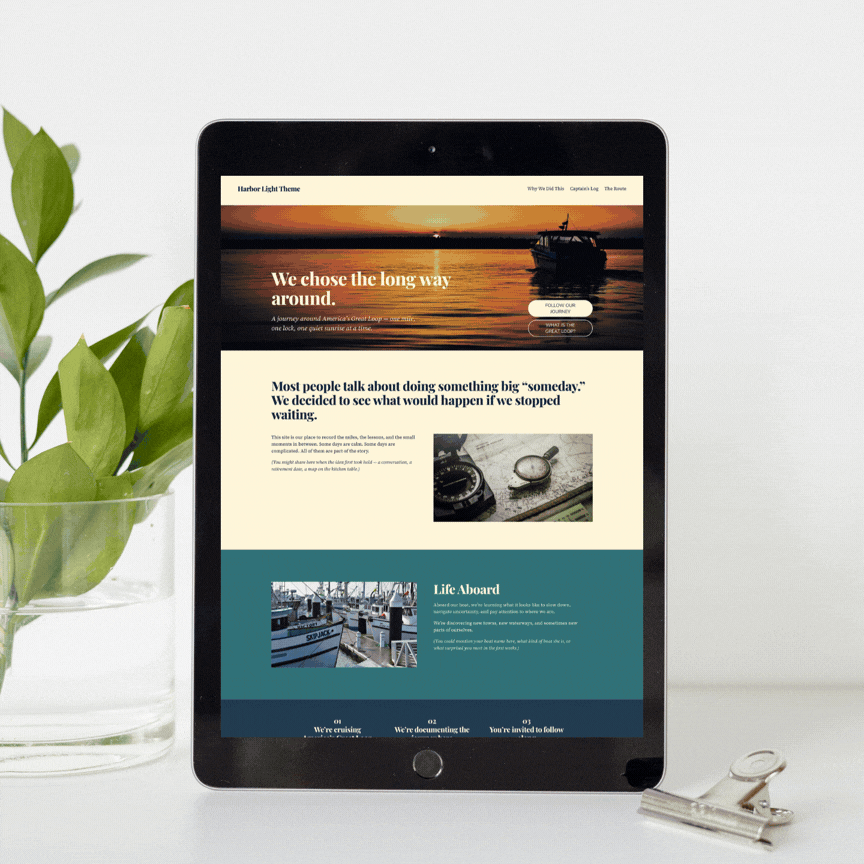 A tablet displaying a travel blog about a life at sea, with a sunset and boat image at the top, and sections about a journey and life aboard ships. It is placed next to a pot of green leaves and a paper clip.