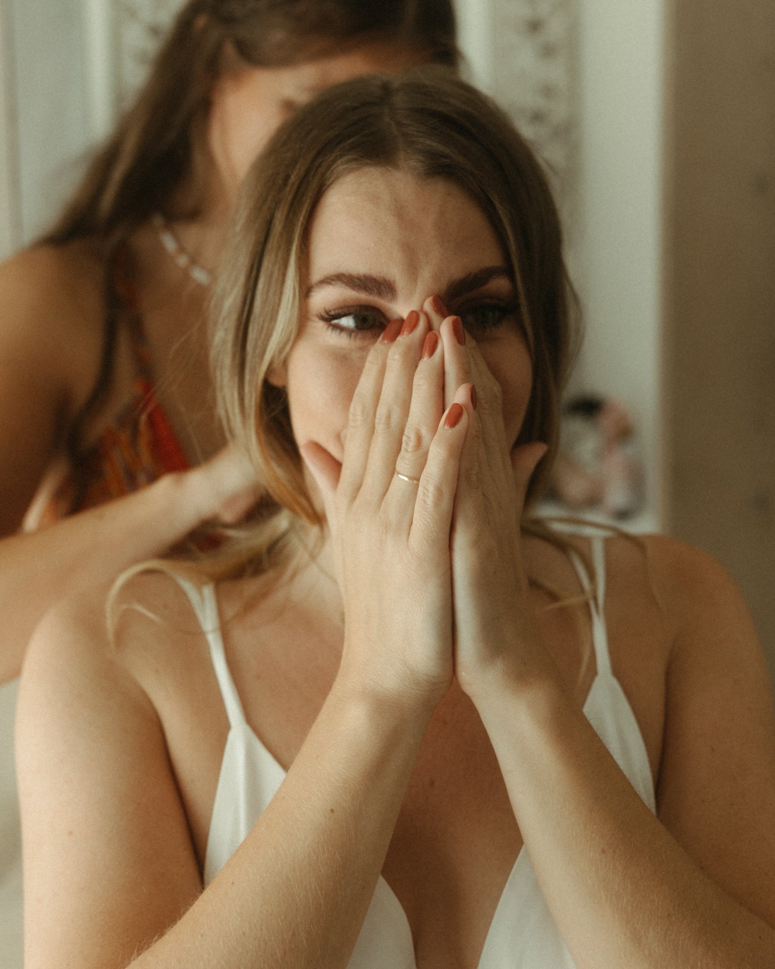 Emotionale Braut hält sich die Hände vor das Gesicht während der Hochzeitsvorbereitung – Heiraten in Recklinghausen