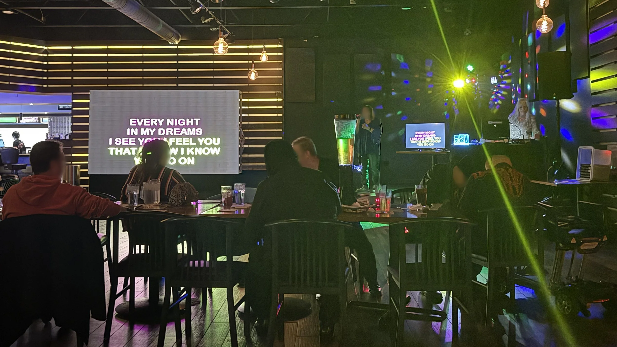 Karaoke host Deb hosting at Lucky Strike Grand Rapids in Wyoming, Michigan, with the crowd, large lyric screen and colorful stage lighting during the GRkaraoke.com Karaoke Marathon 2026