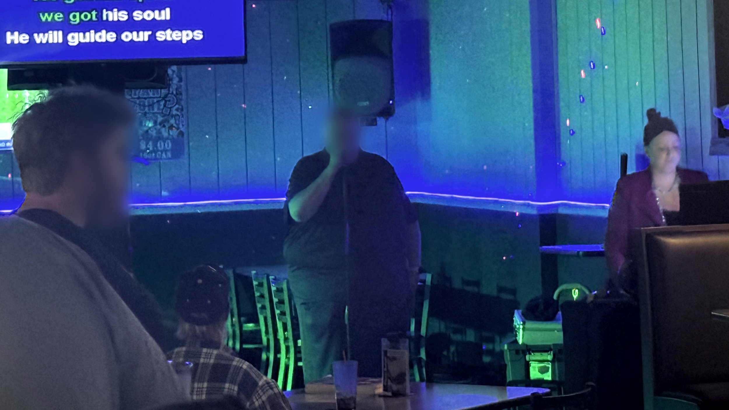 View from the bar at Embassy Bar & Grill in West Olive, Michigan, showing a singer performing karaoke with host Cole M. during the GRkaraoke.com Karaoke Marathon 2026