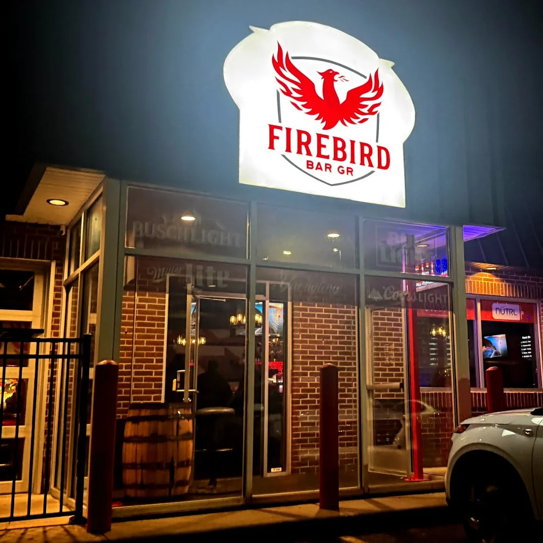 Exterior of Firebird Bar GR on the West Side of Grand Rapids, Michigan, showing the illuminated Firebird sign and entrance at night during the final stop of the GRkaraoke.com Karaoke Marathon 2026