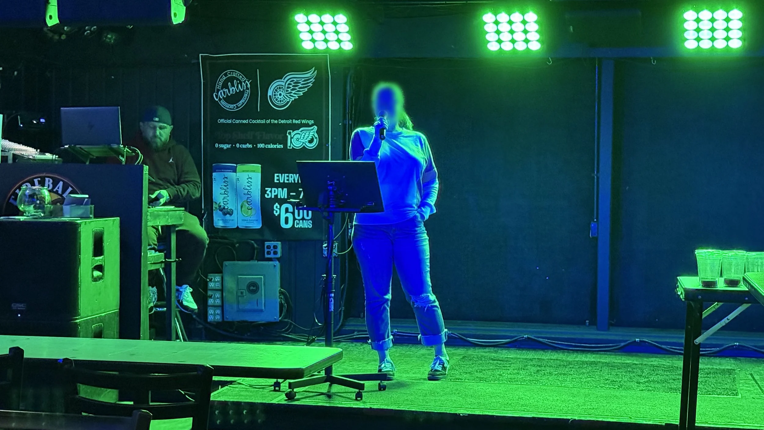 Karaoke host Jeff S. hosting karaoke at Log Cabin in Grand Rapids, Michigan, with a singer performing under stage lights during the GRkaraoke.com Karaoke Marathon 2026