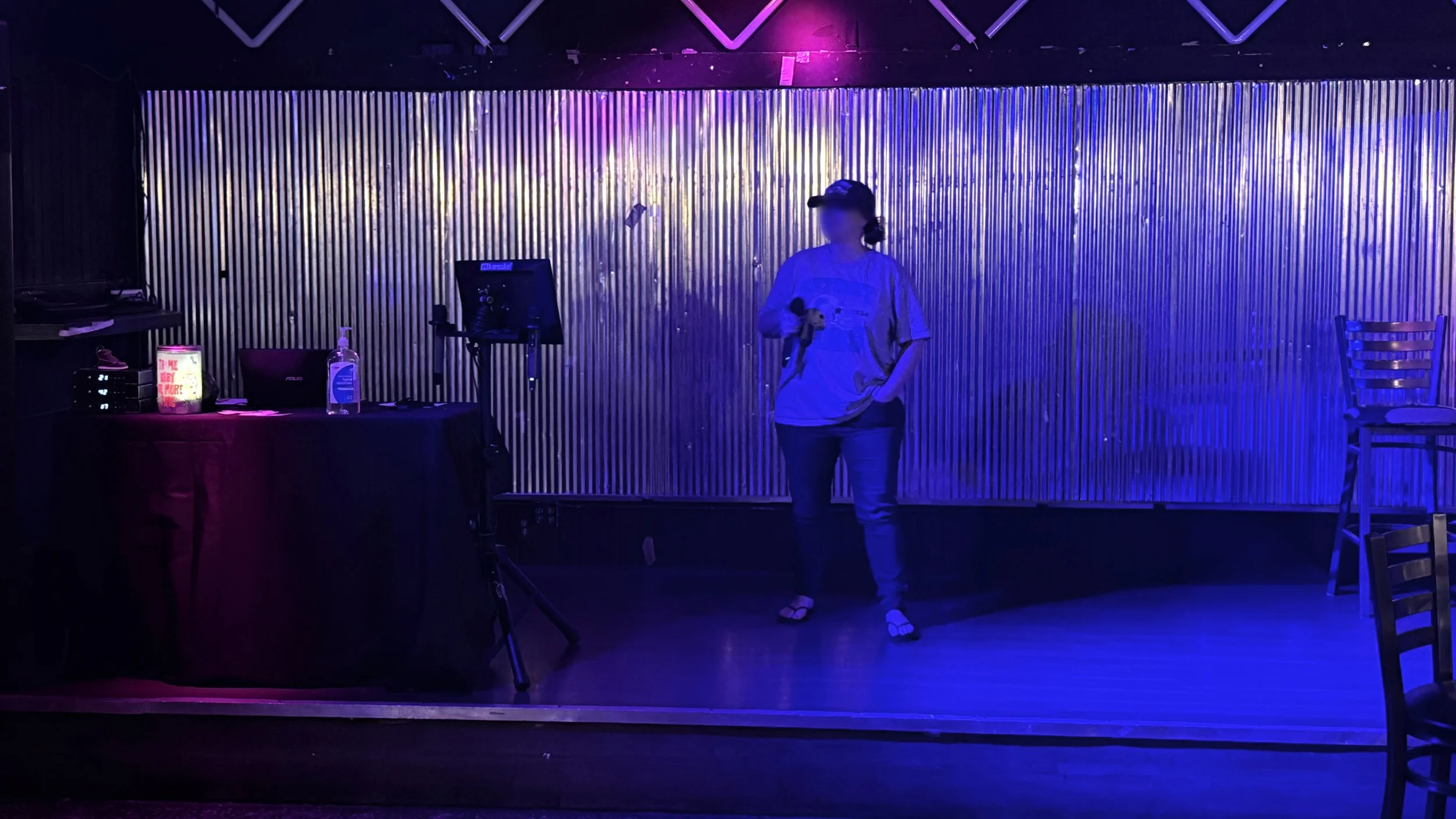 Singer performing karaoke on the raised stage at River City Saloon in Grand Rapids, Michigan, under blue stage lighting during the GRkaraoke.com Karaoke Marathon 2026