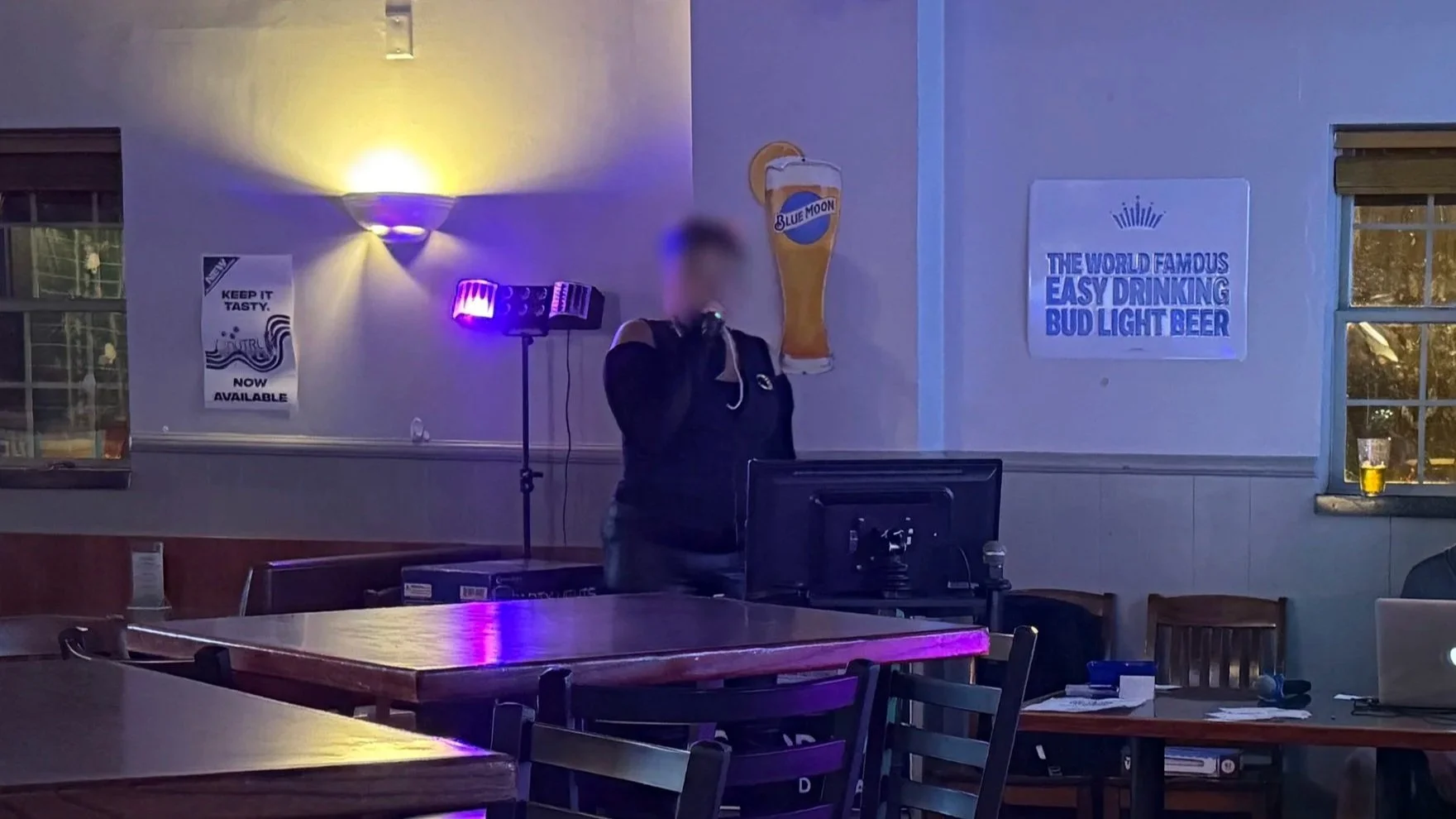 Singer performing karaoke at Last Chance Tavern & Grill in Grand Rapids, Michigan, showing the karaoke area, dining tables and colorful lighting during the GRkaraoke.com Karaoke Marathon 2026