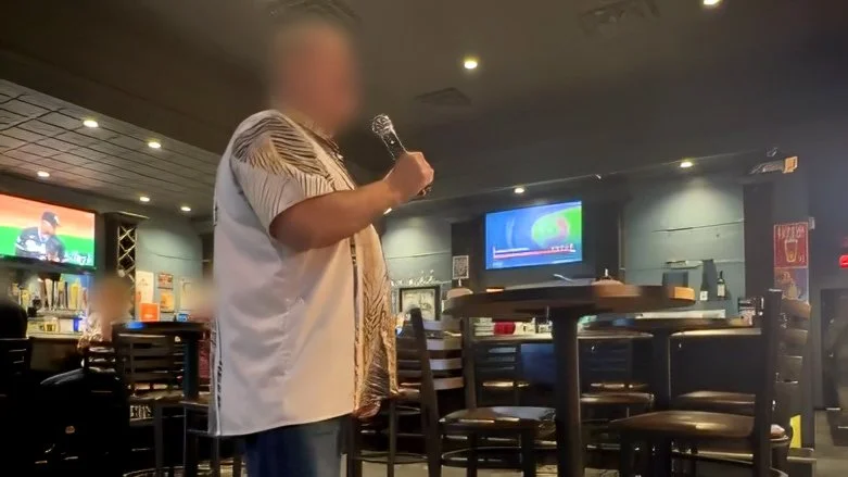 View from the karaoke host booth at PigSkins & Pints in Grand Rapids, Michigan, showing a singer performing among the bar and restaurant seating during the GRkaraoke.com Karaoke Marathon 2026