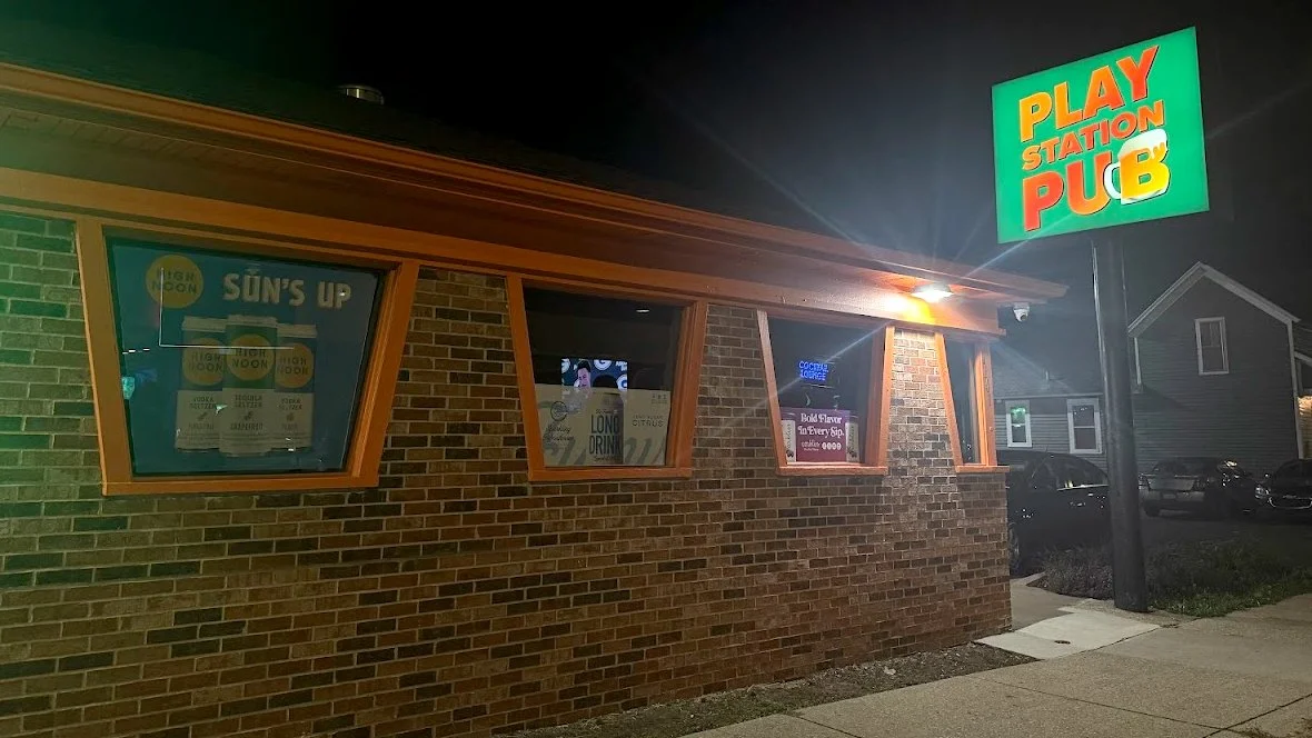 Exterior of Play Station Pub on Leonard Street in Grand Rapids, Michigan, showing the illuminated bar sign and former Pizza Hut building during the GRkaraoke.com Karaoke Marathon 2026