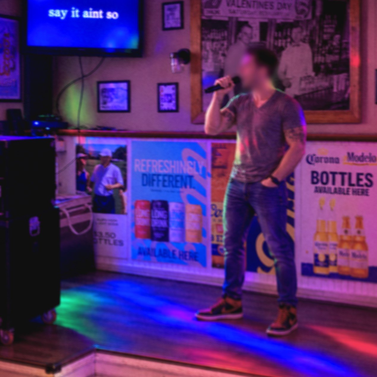 Singer performing karaoke on stage at Bow Tie Tavern & Grill in Sparta, Michigan, with “Say It Ain’t So” lyrics on screen and colorful stage lighting during the GRkaraoke.com Karaoke Marathon 2026