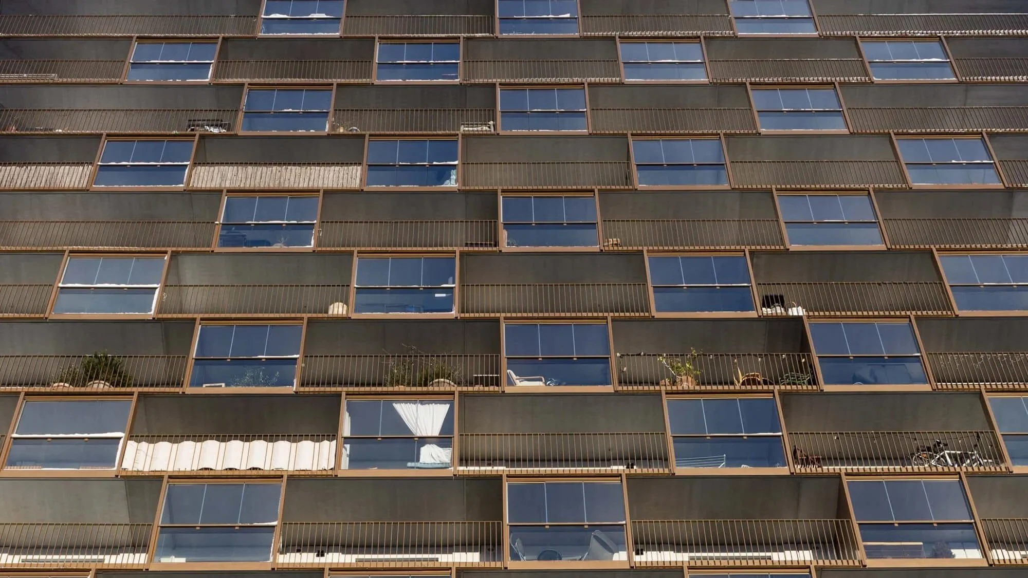 Modern residential building with repeating balconies and geometric architecture.
