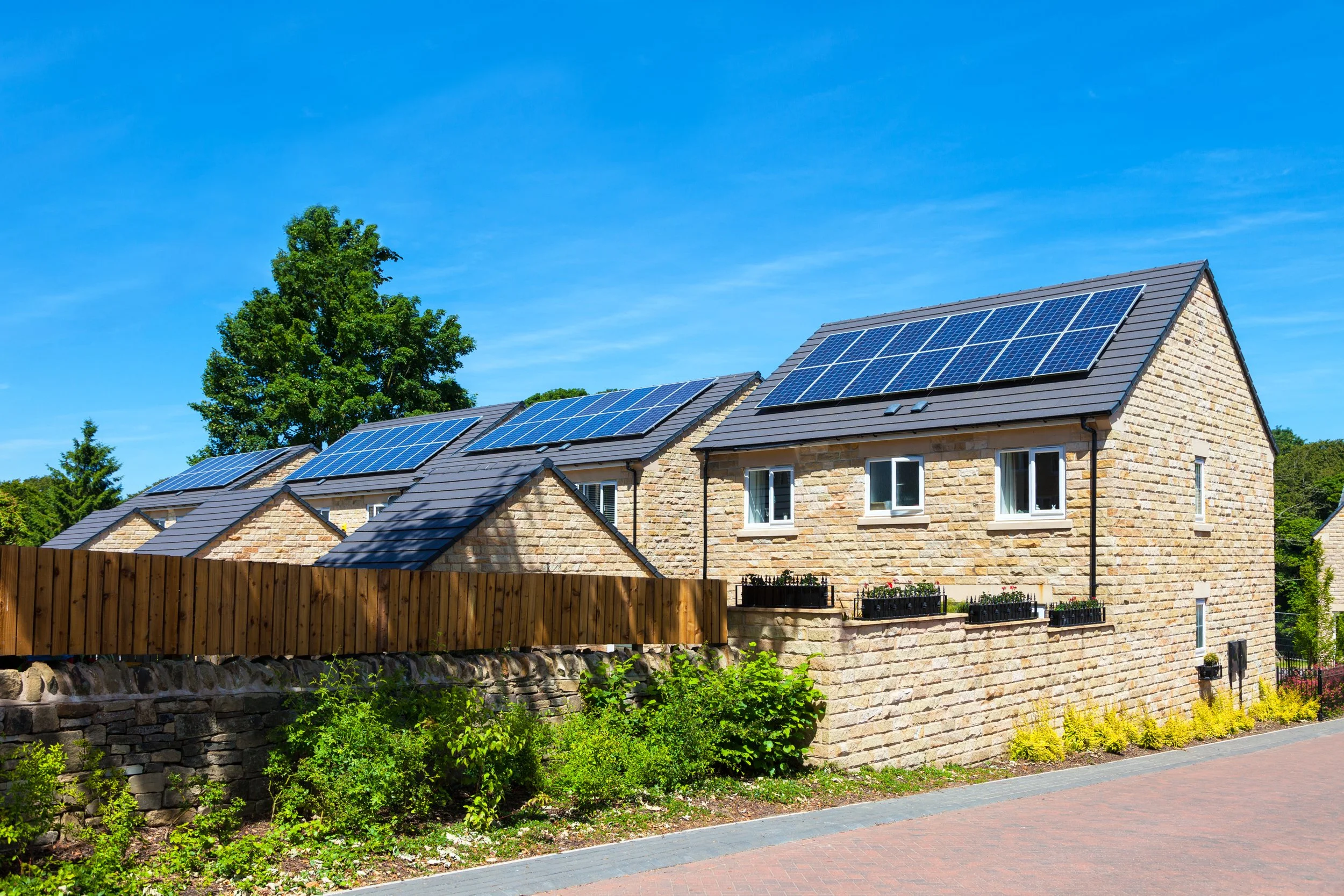 A row of modern houses with solar panels on their roofs, benefiting from an renewable energy. In the UK.