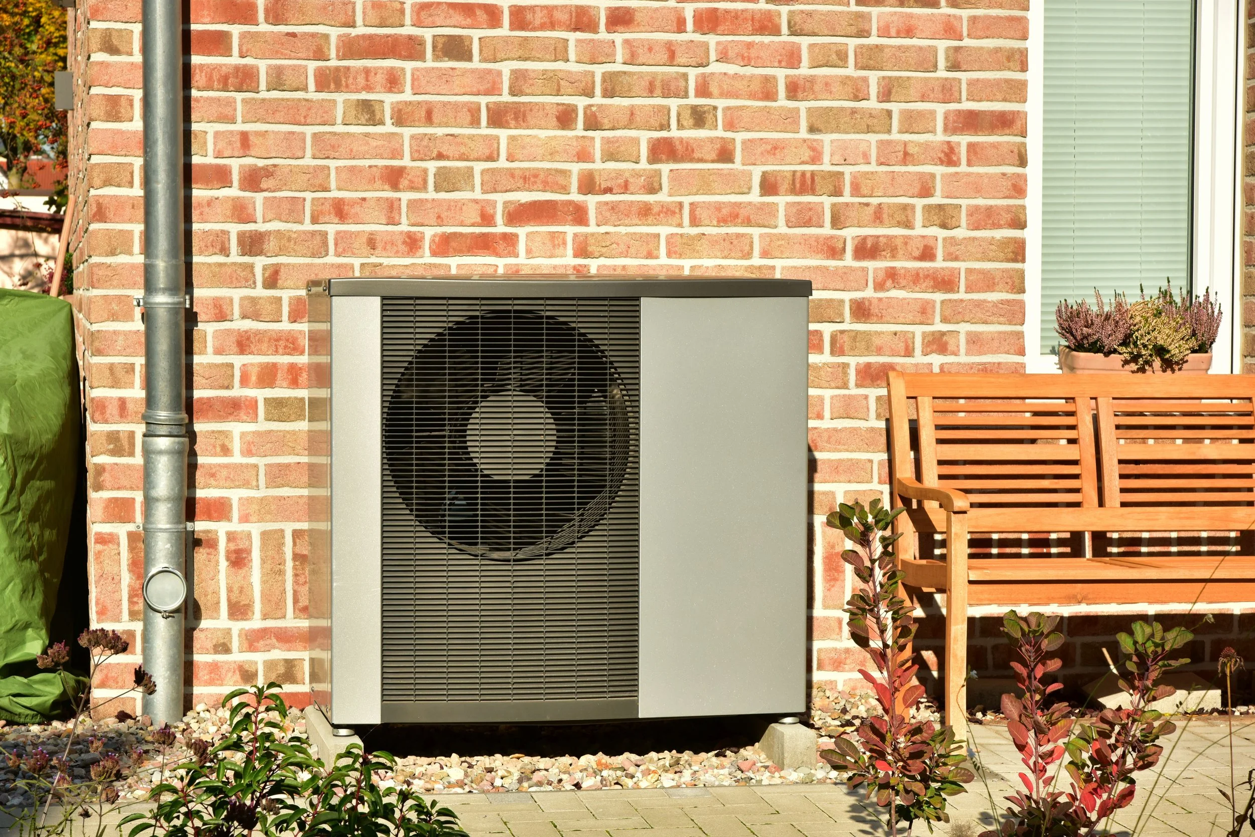 An outdoor air source heat pump. Using wind to generate clean and renewable energy, and saving money on the energy bills in the UK.