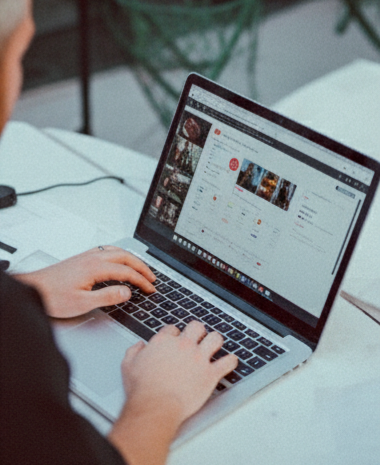 The social media manager using a laptop at a desk, browsing social media.