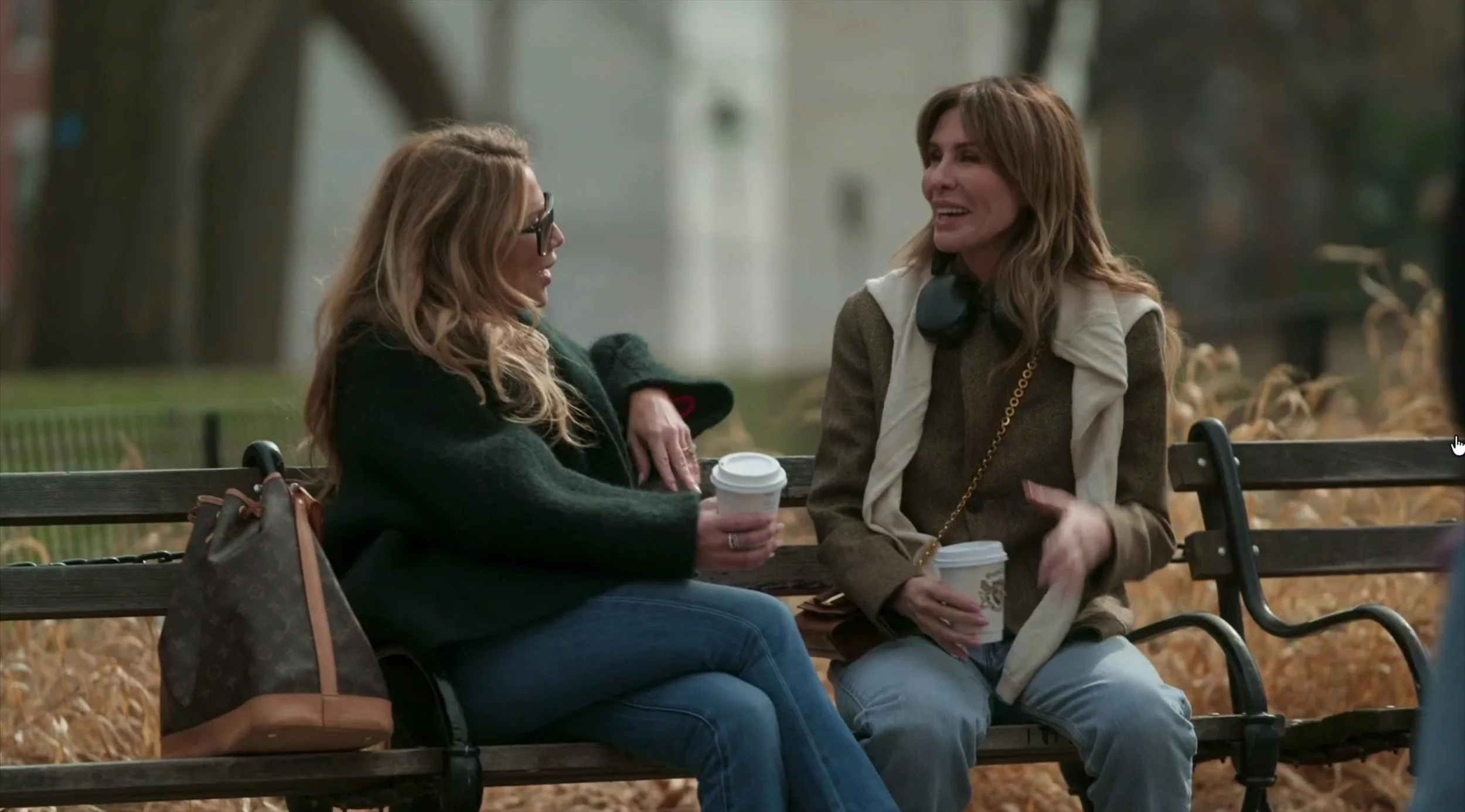Daisy Toye and Carole Radziwill having coffee on a Washington Square Park bench, with Daisy's Louis Vuitton Noé beside her, on The Real Housewives of New York City.