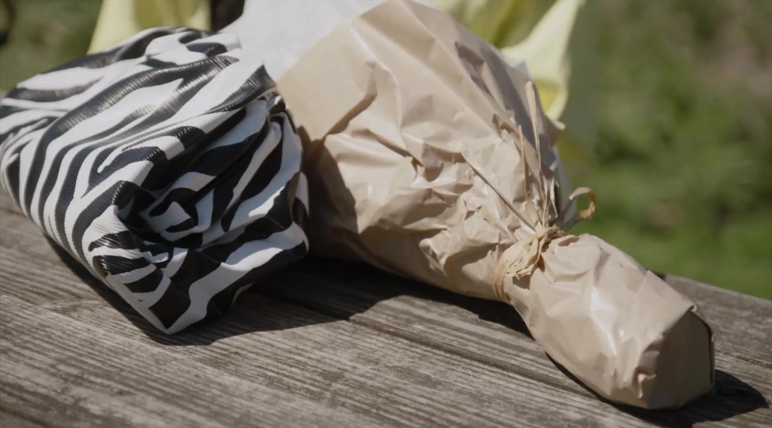 Close-up of the gathered black-and-white zebra-print pouch on the picnic table.