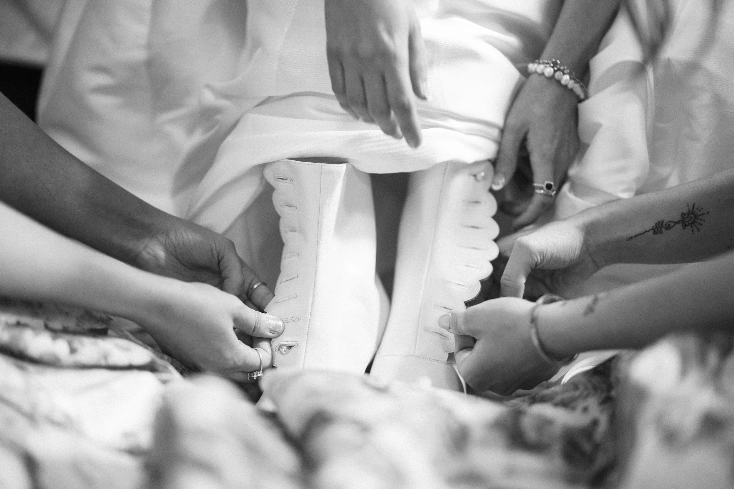 bridesmaids helping bride put on shoes