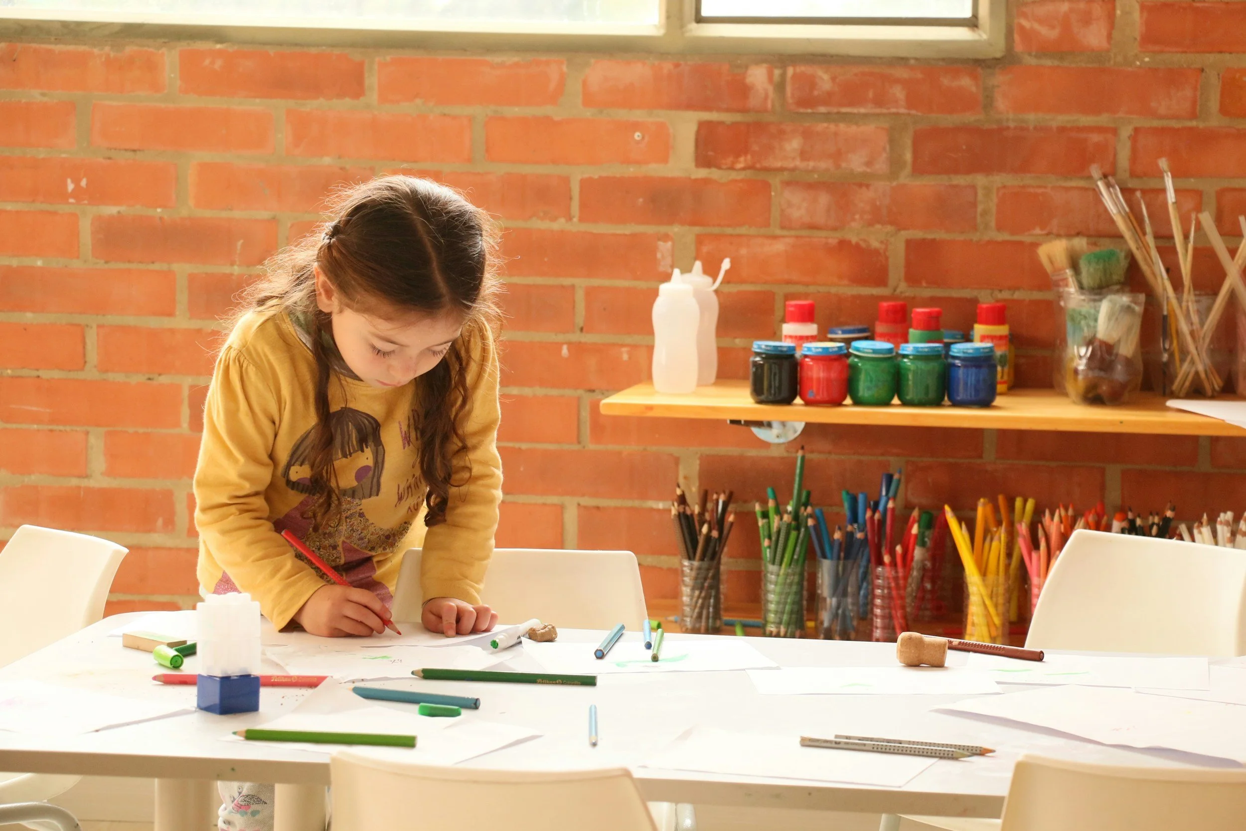 Children in an expressive art group sharing their artwork, learning emotional awareness and communication through creative play. Medway MA