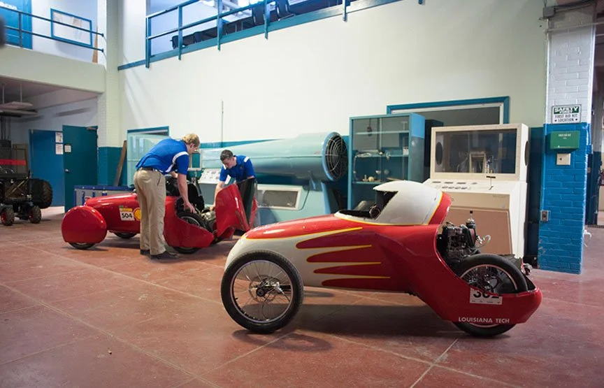 A streamlined three-wheel EcoCar prototype sits inside the Louisiana Tech engineering lab.