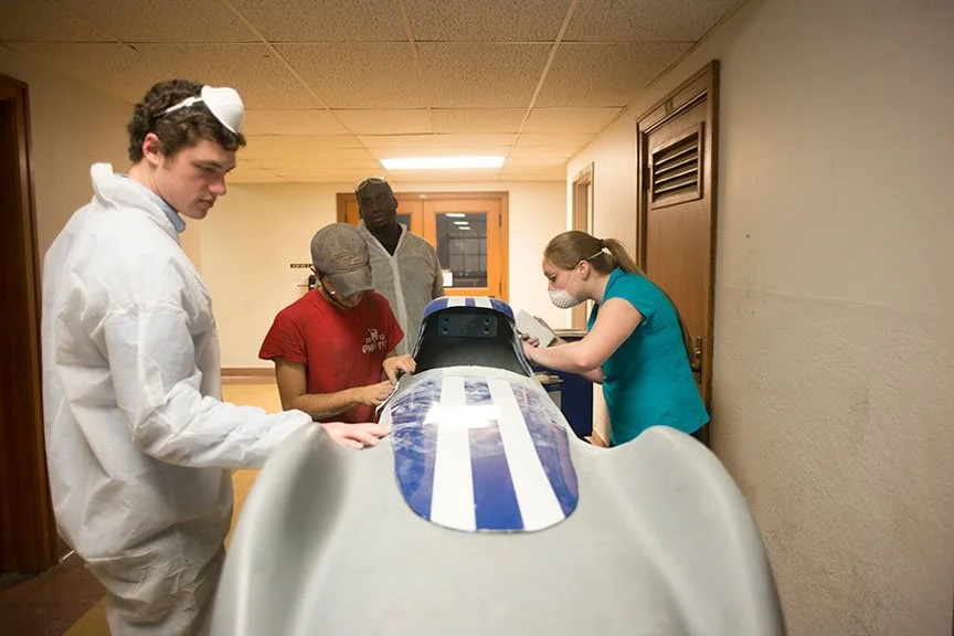 Engineering students work around the nose of a Louisiana Tech EcoCar prototype.