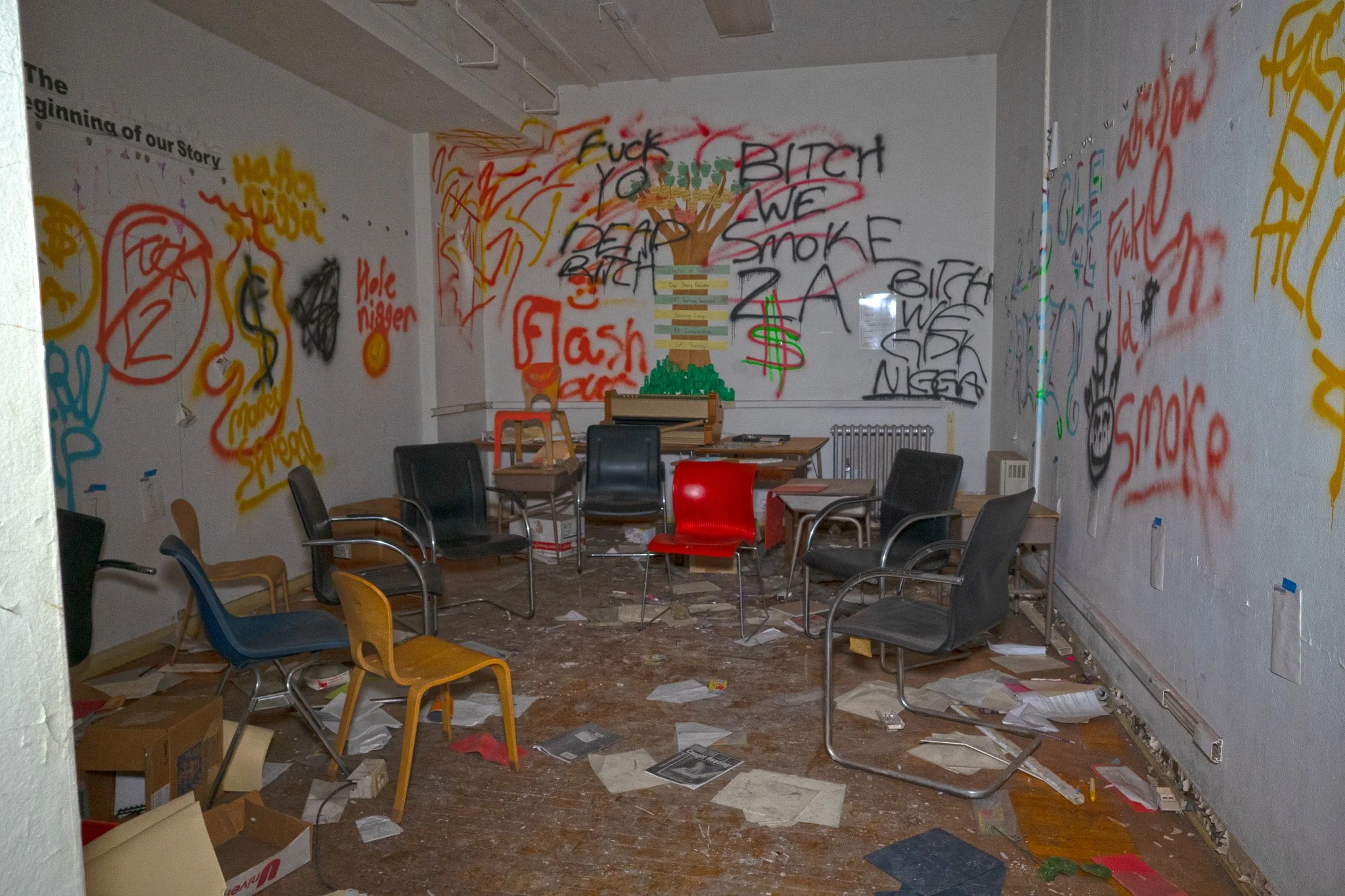 Near the main 1st floor concourse a tree mural on the wall in a room is tagged over