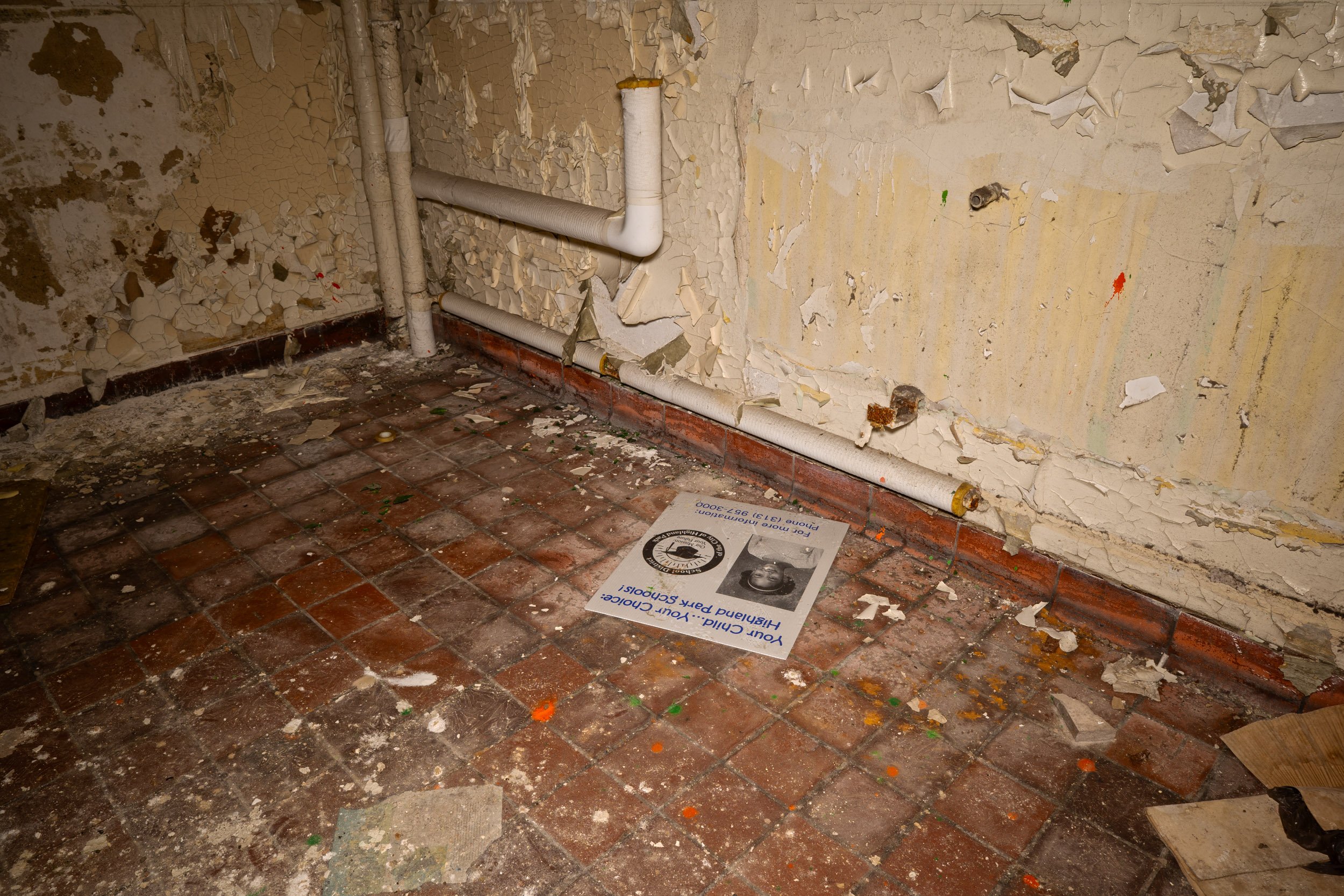 A poster encouraging people to enroll their kids in Highland Park Schools lies on the ground of the stairwell
