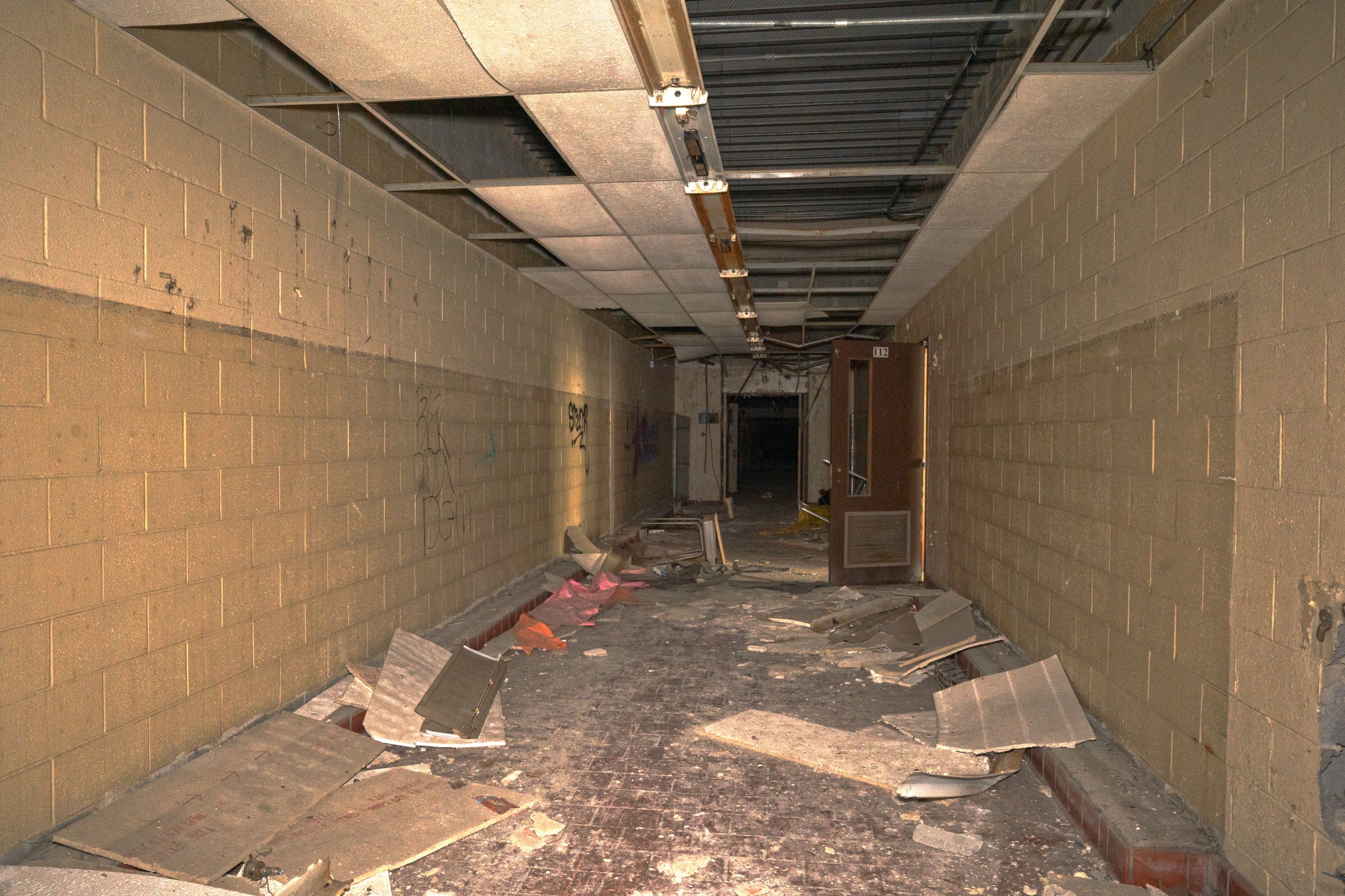 1st floor hallway in the additon made at a later date likely in the 1950s or 60s due to the CMU design and drop ceiling