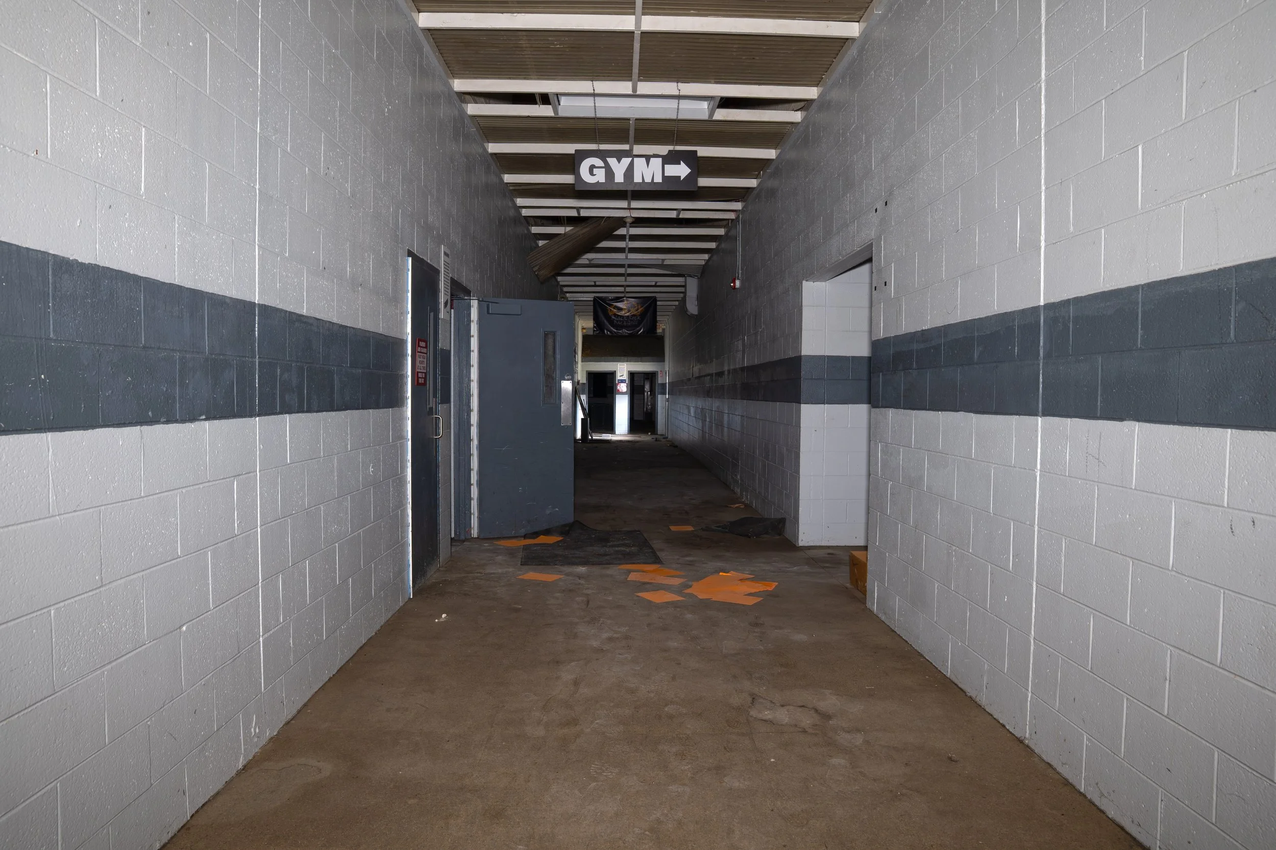 Mid section of the hallway leading to basketball courts on the right and sandy courts on the left