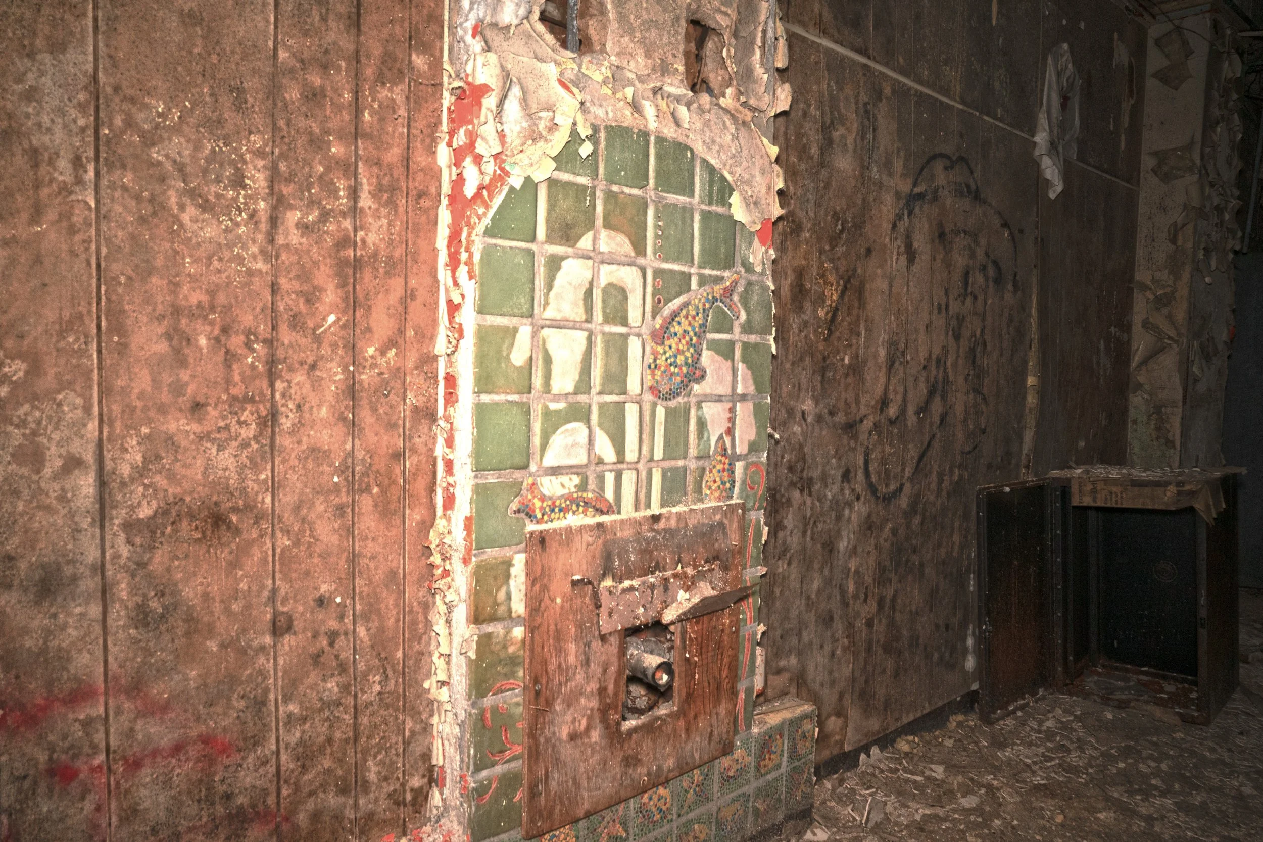 A tile mural where a drinking fountain once stood on the 1st floor