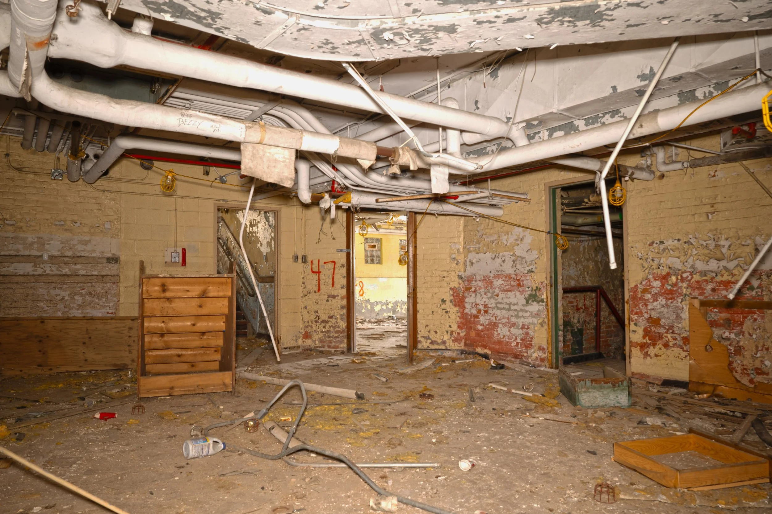 basement hallway to the far left is the stairs to the 1st floor in the middle is a basement classroom entrance and to the far right the boiler room entrance 