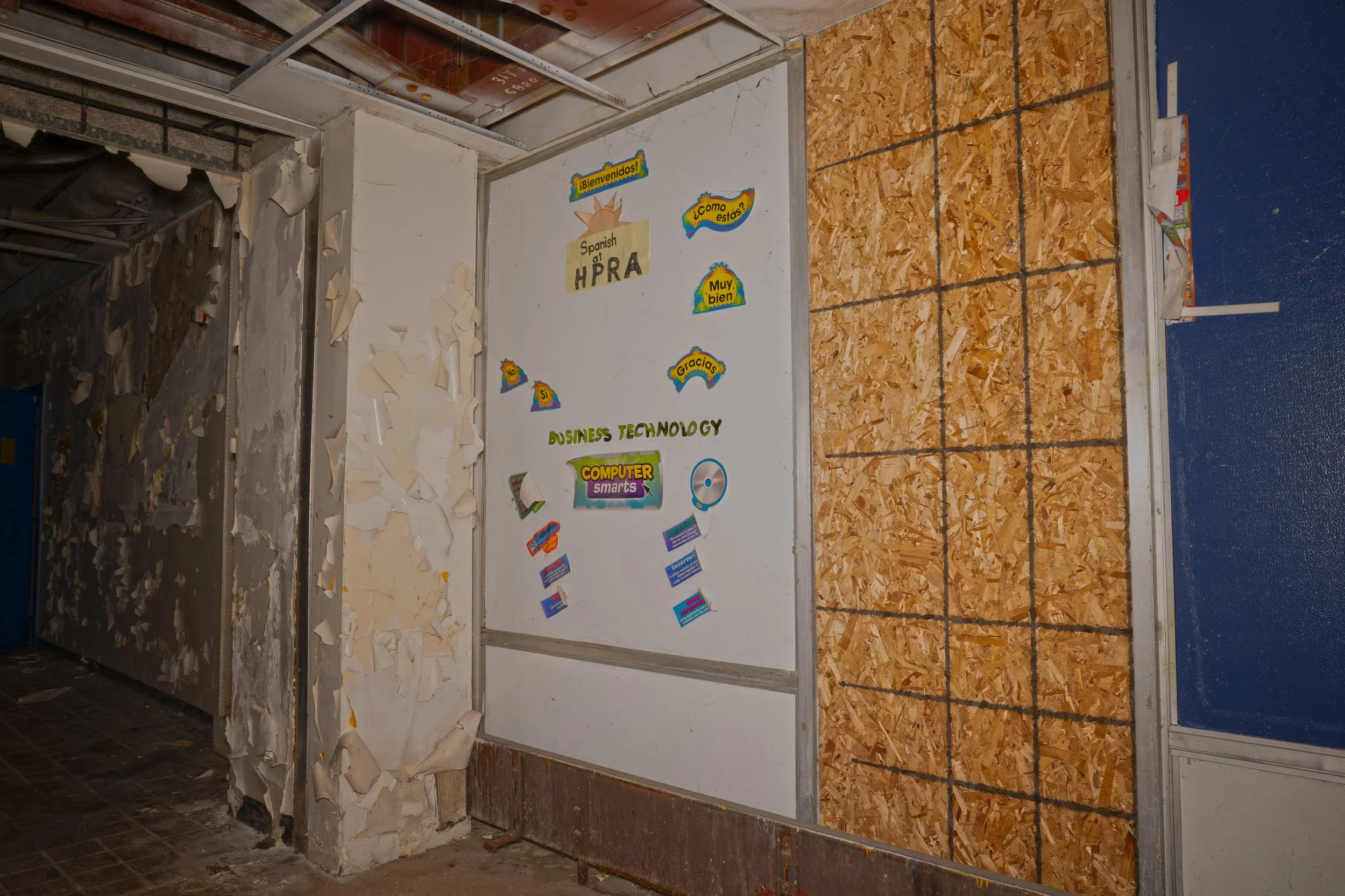 The doorway between the 1984 and 1924 additions feature a sticker board with the initials of the school and various Spanish Phrases  