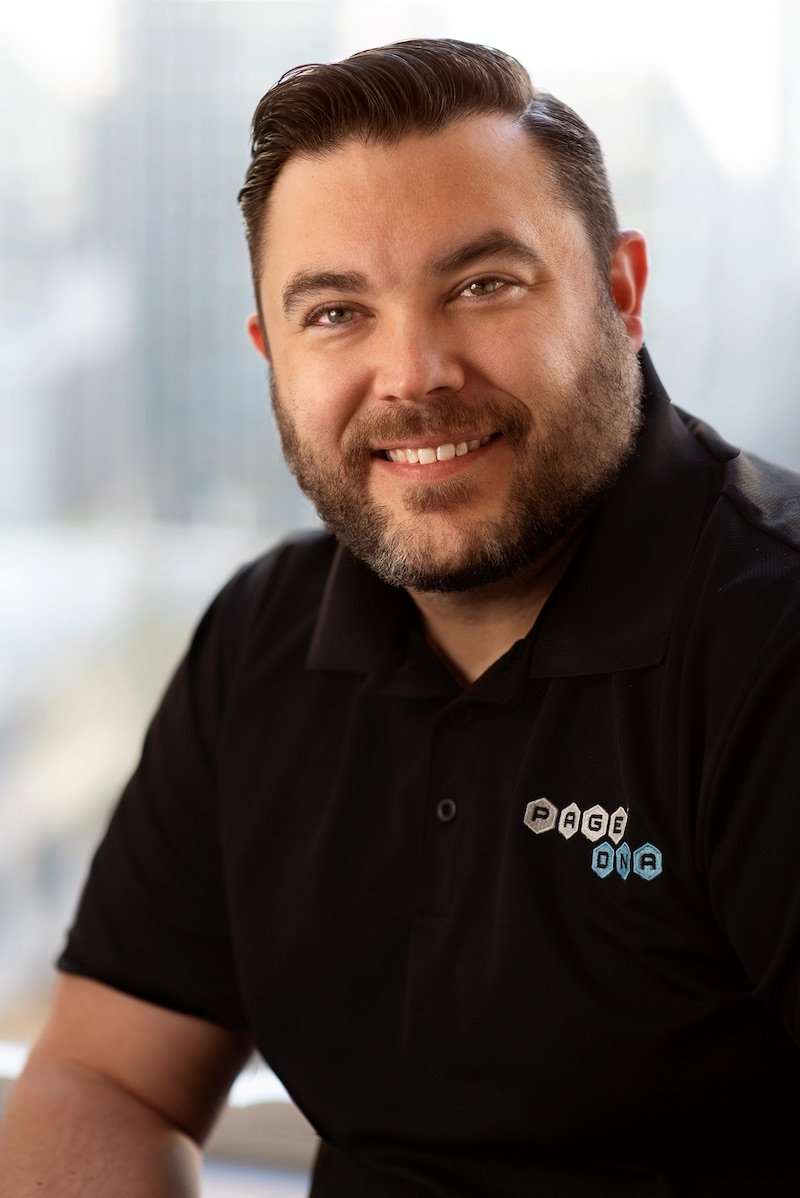 Headshot of another bearded man wearing a polo shirt with the company logo.