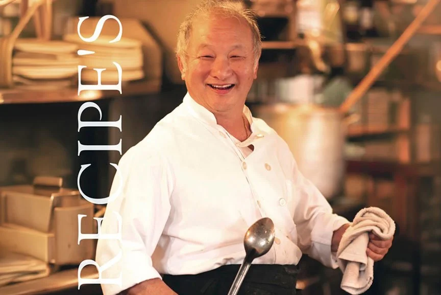 A smiling male chef in a white uniform holding a towel and a ladle in a kitchen. The word 'RECIPE'S' is vertically aligned on the left side.