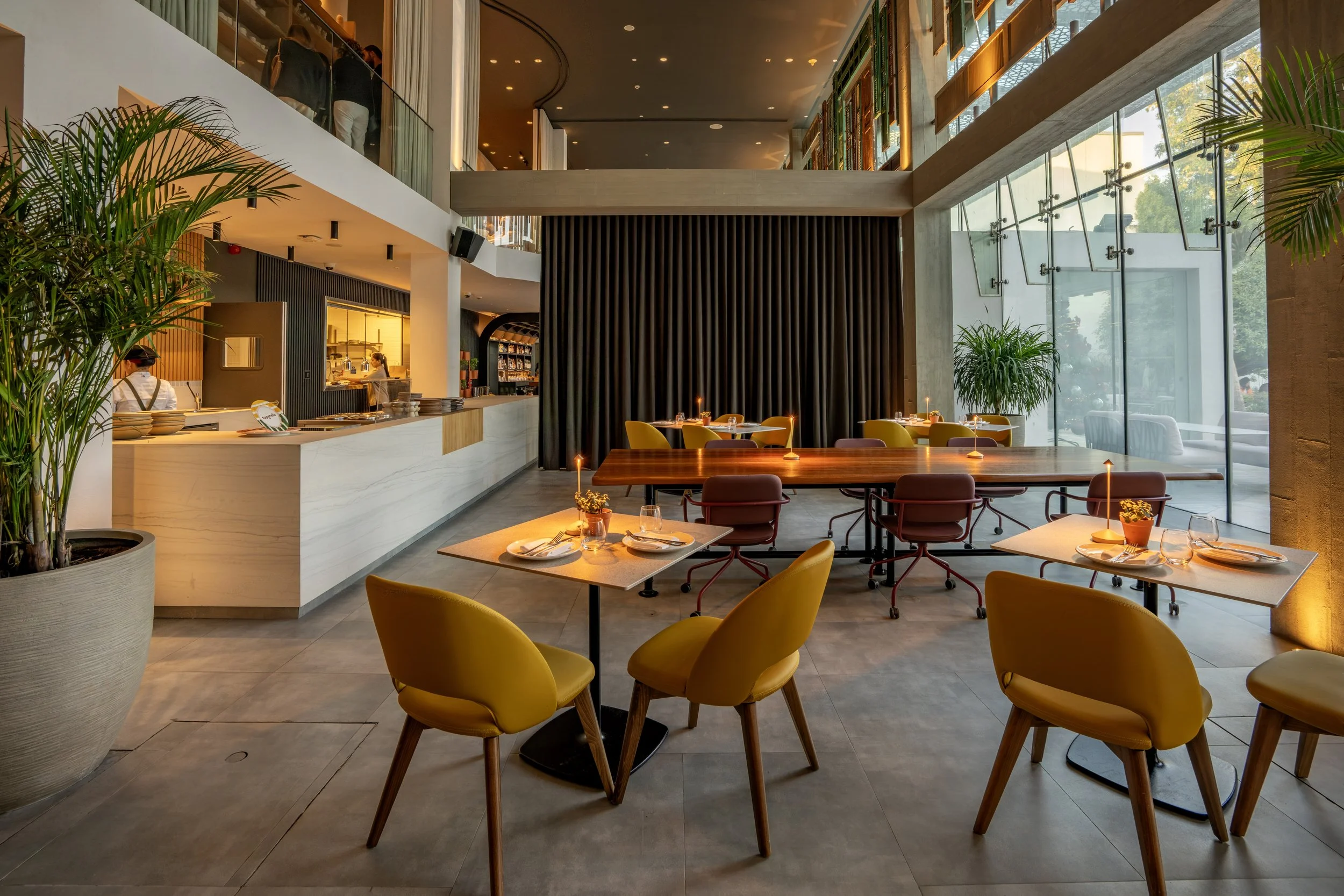 Yellow chairs, soft lamplight, an open kitchen.