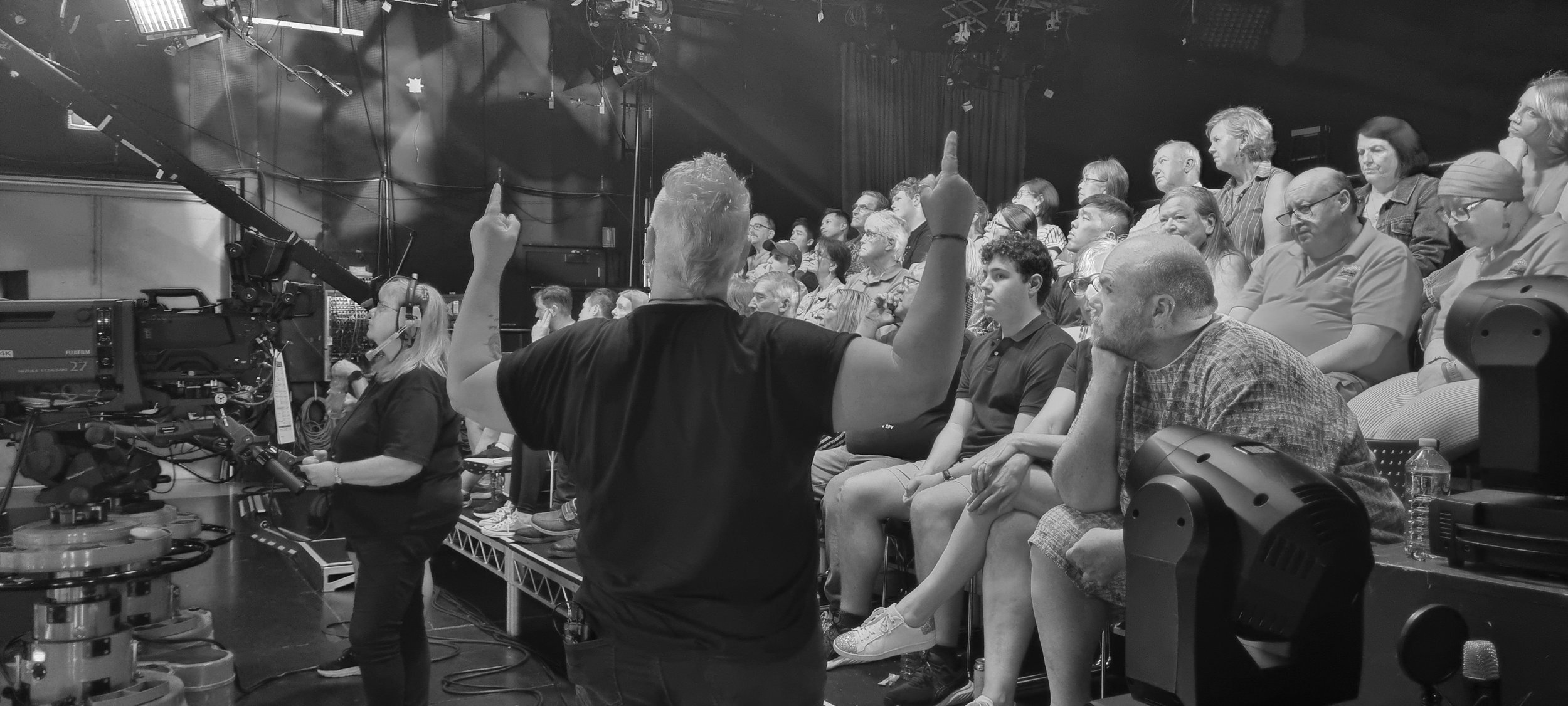 Julia Wilson energizing the crowd with her humor and charisma during a live audience warm-up session