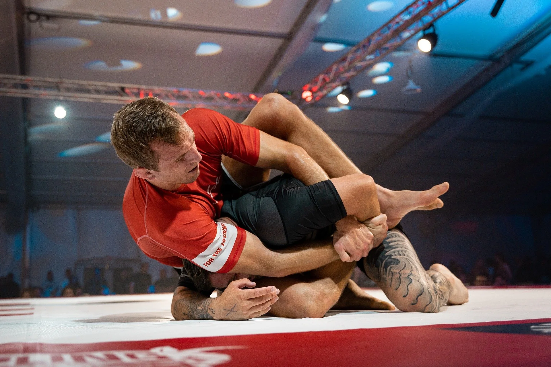 Two jiu-jitsu practitioners grappling during training, demonstrating focus and technique in martial arts.