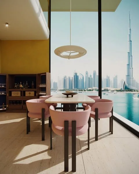 Modern dining area with a table and six pink chairs, large windows showing a city skyline with the Burj Khalifa and Dubai Water Canal.