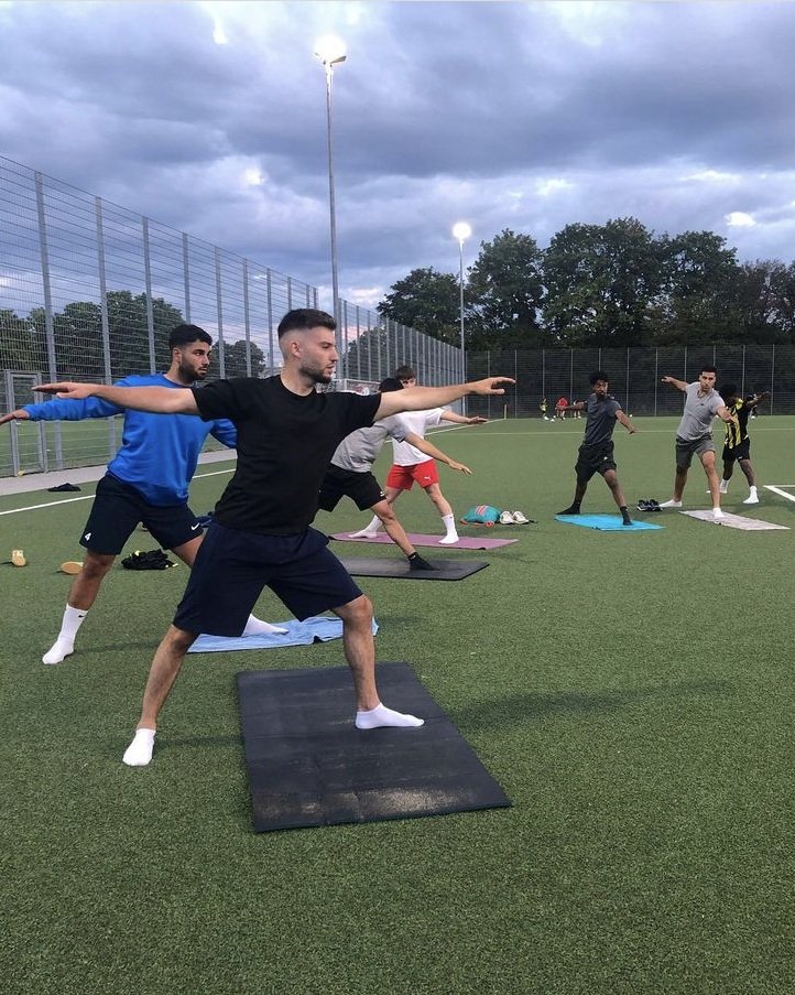 Männer Fußballmannschaft vom SV Olympiadorf beim Yoga.