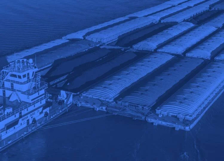 Aerial view of a harbor with a docked ship and several covered cargo containers on the dock.
