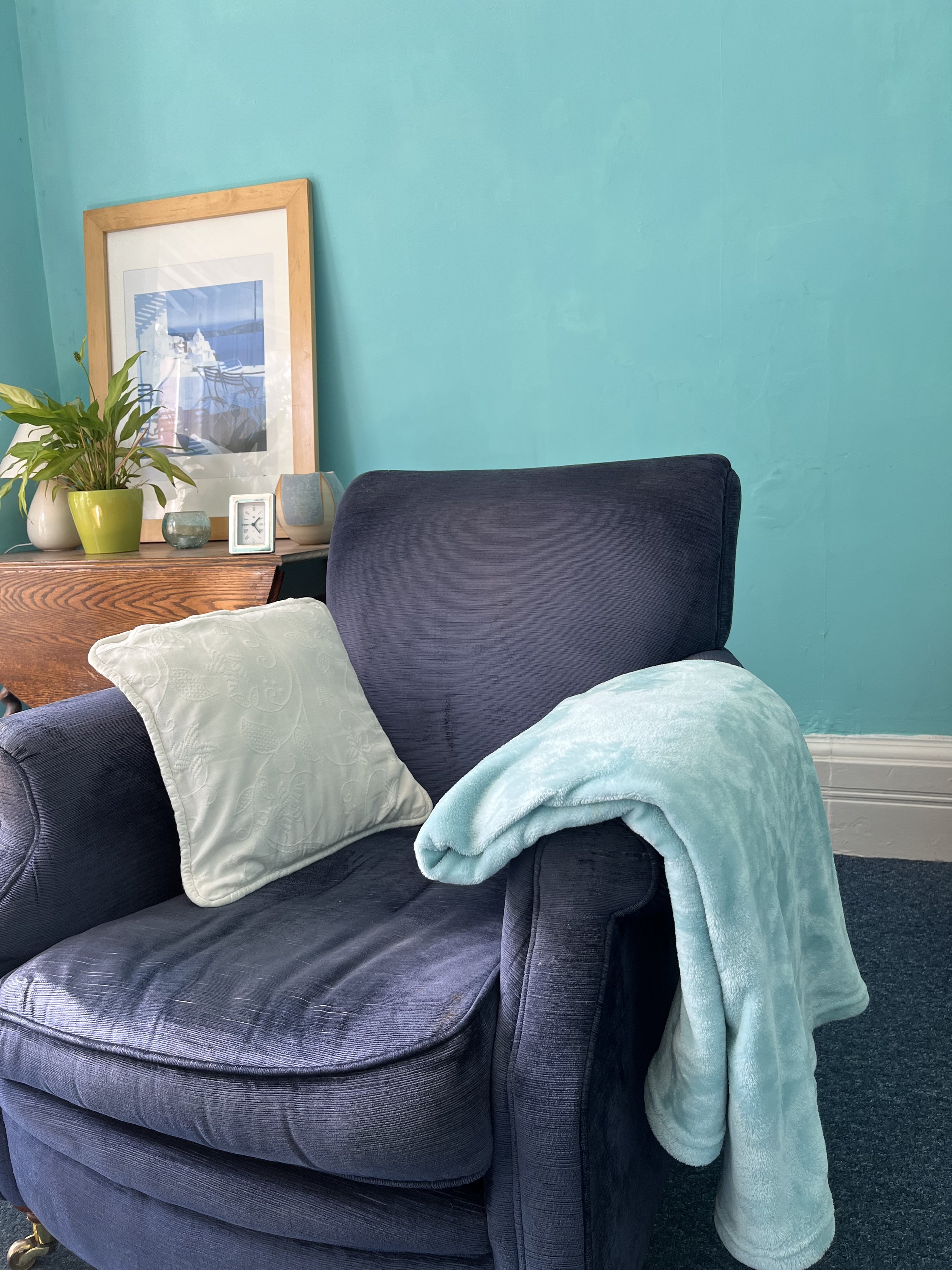 Comfortable upholstered armchair in a calm, welcoming counselling room.